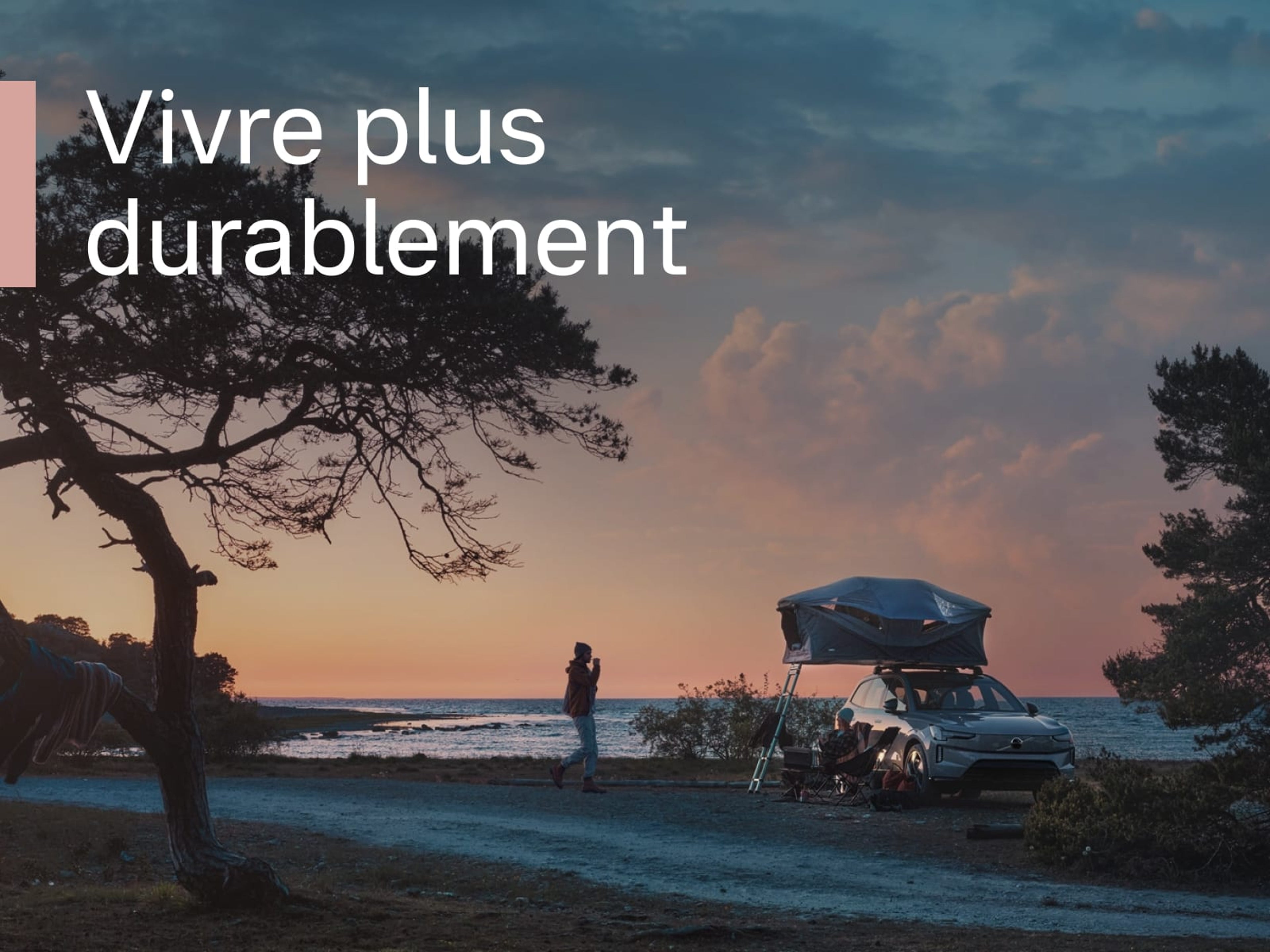 Une Volvo avec tente de toit est garée au bord de la mer au coucher du soleil, avec un texte blanc au premier plan : Vivre plus durablement.