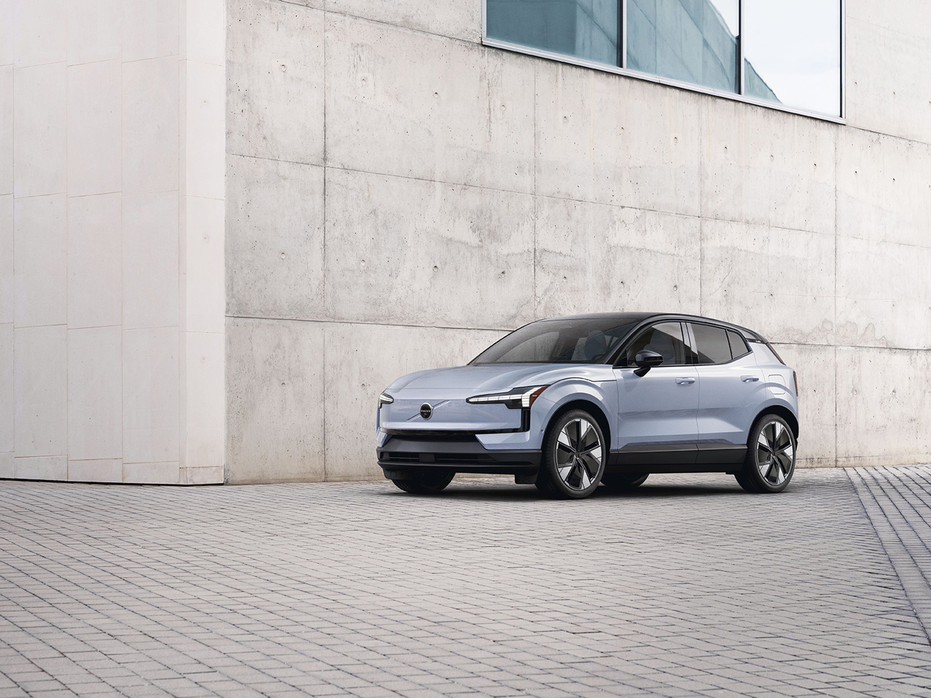 Cloud Blue Volvo EX30 fully electric parked in front of building