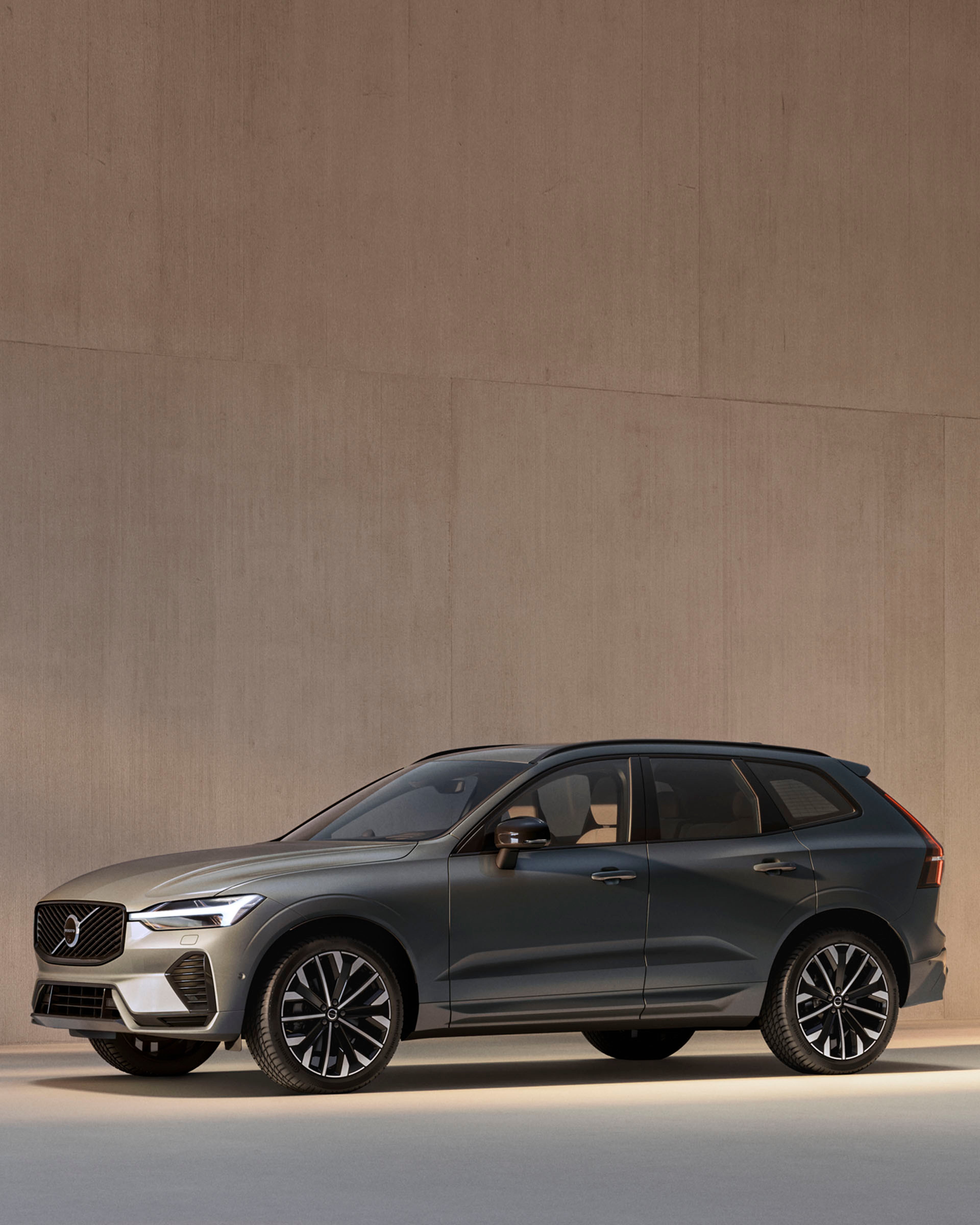 Volvo XC60 B5 mild hybrid vista lateral frontal destacando sus luces LED y sus llantas en un patio a la luz del día