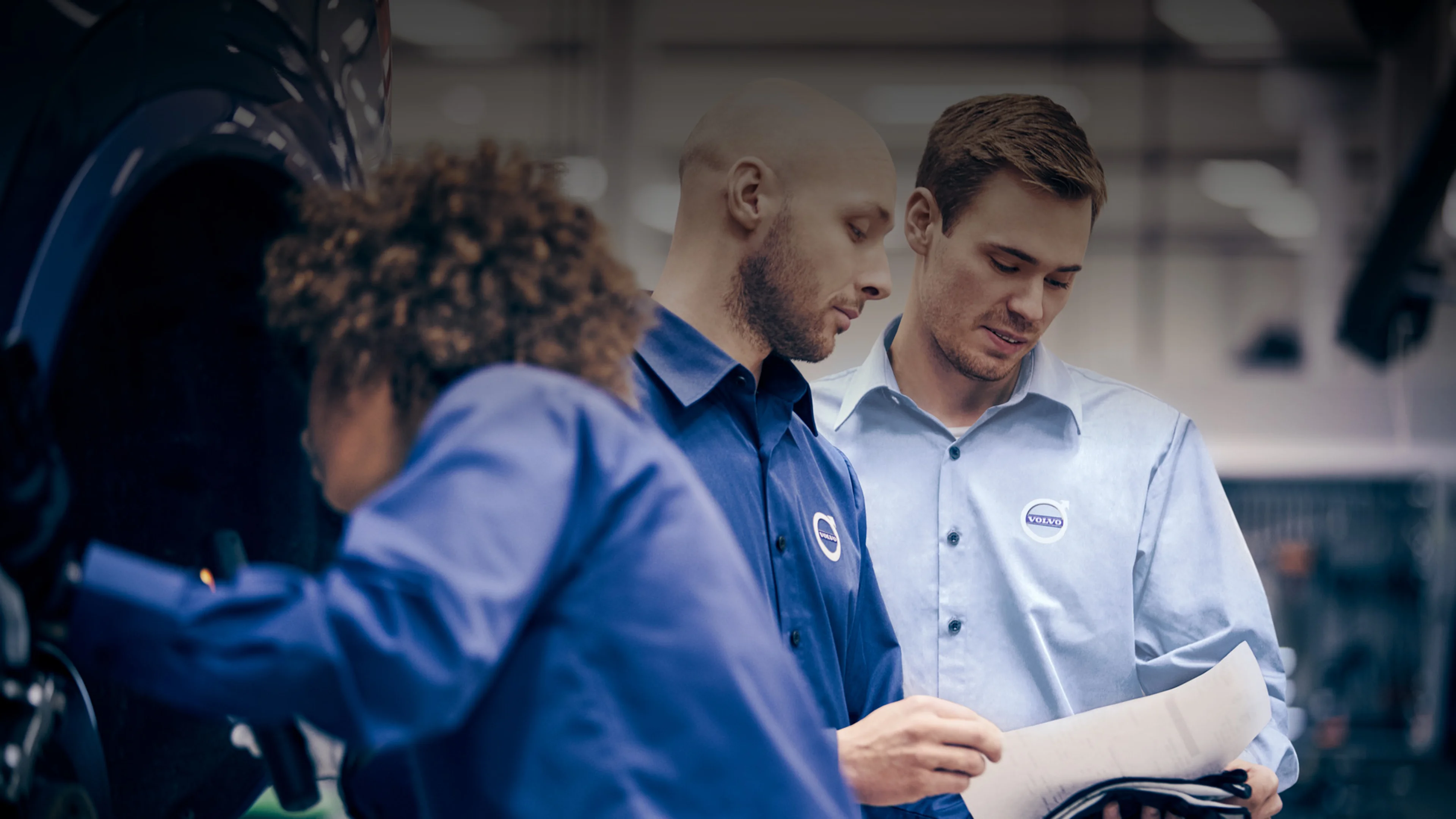 Three Volvo service technicians at work.