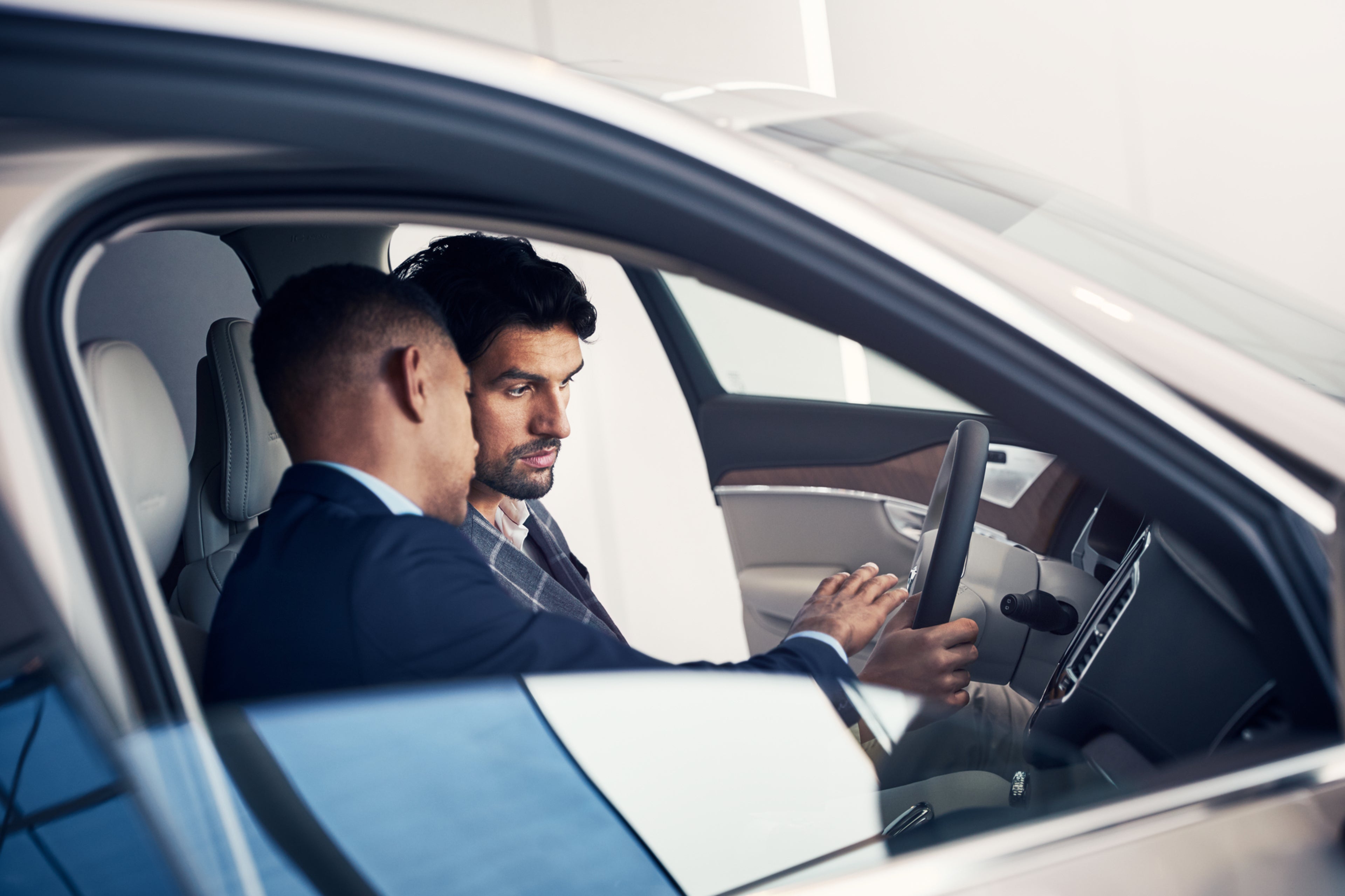 Márkakereskedő beszélget egy ügyféllel egy Volvóban