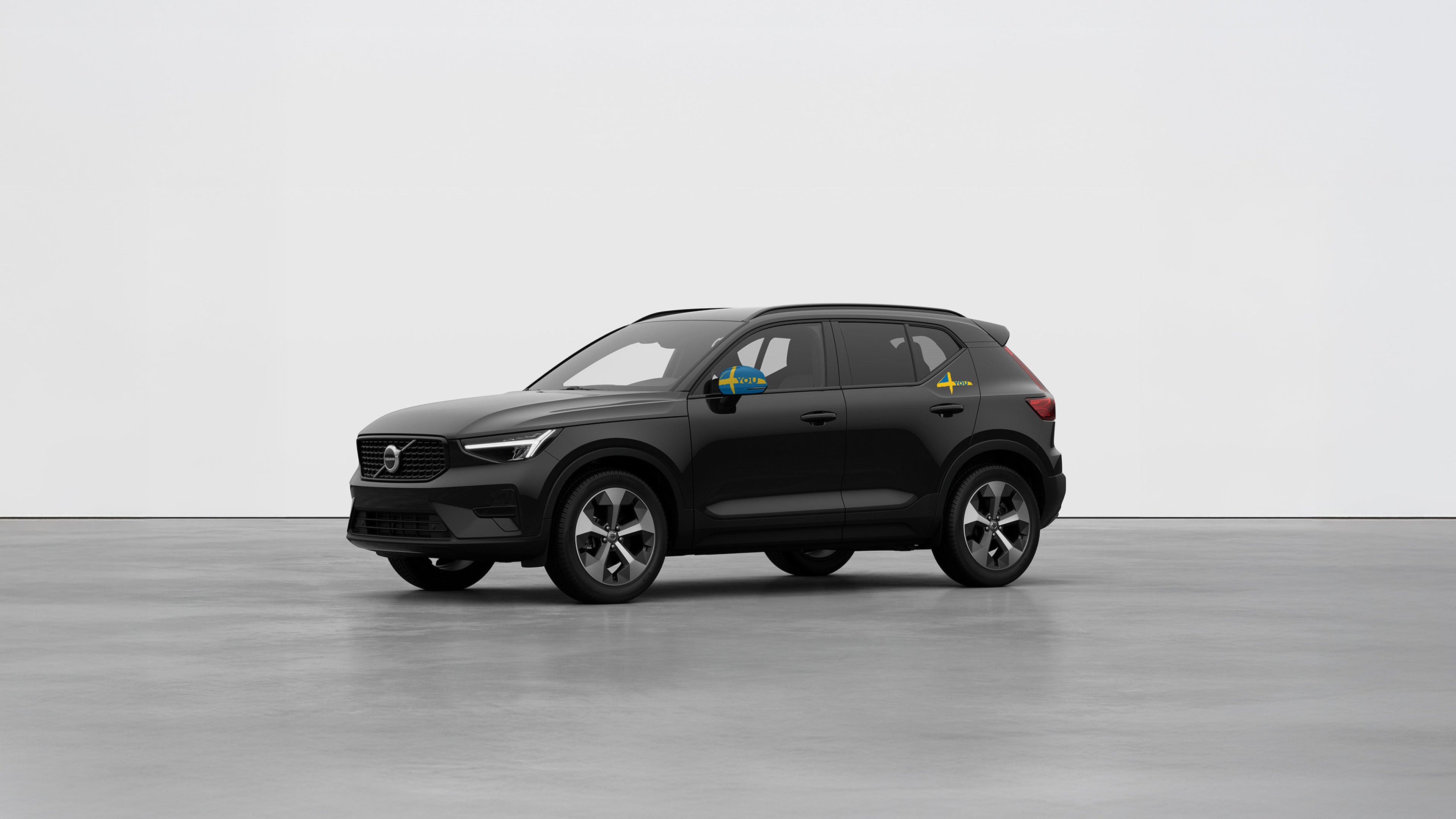 Ein schwarzer Volvo XC40 steht in einer weißen Studioumgebung.