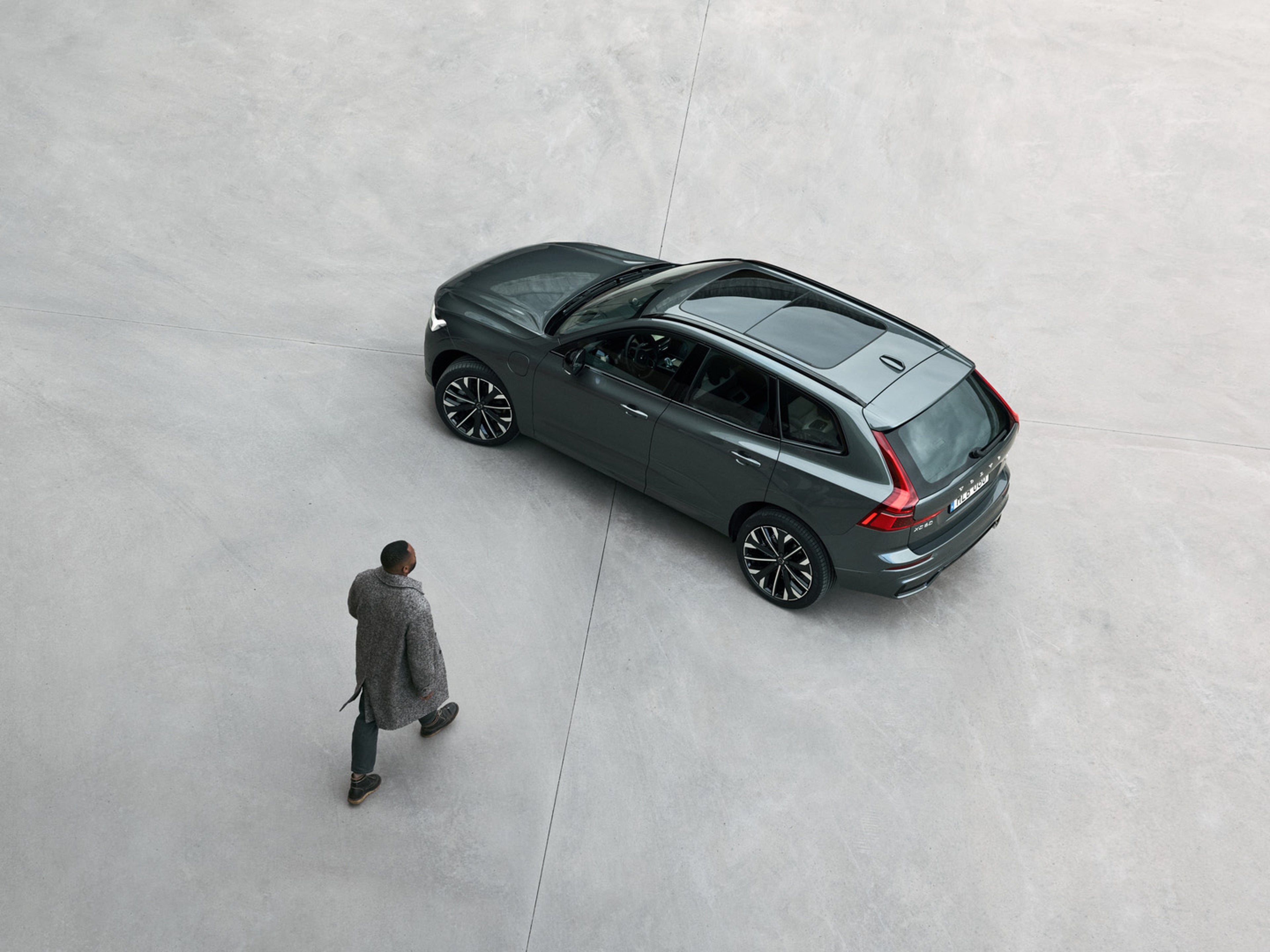 Person walking on grey ground towards XC60