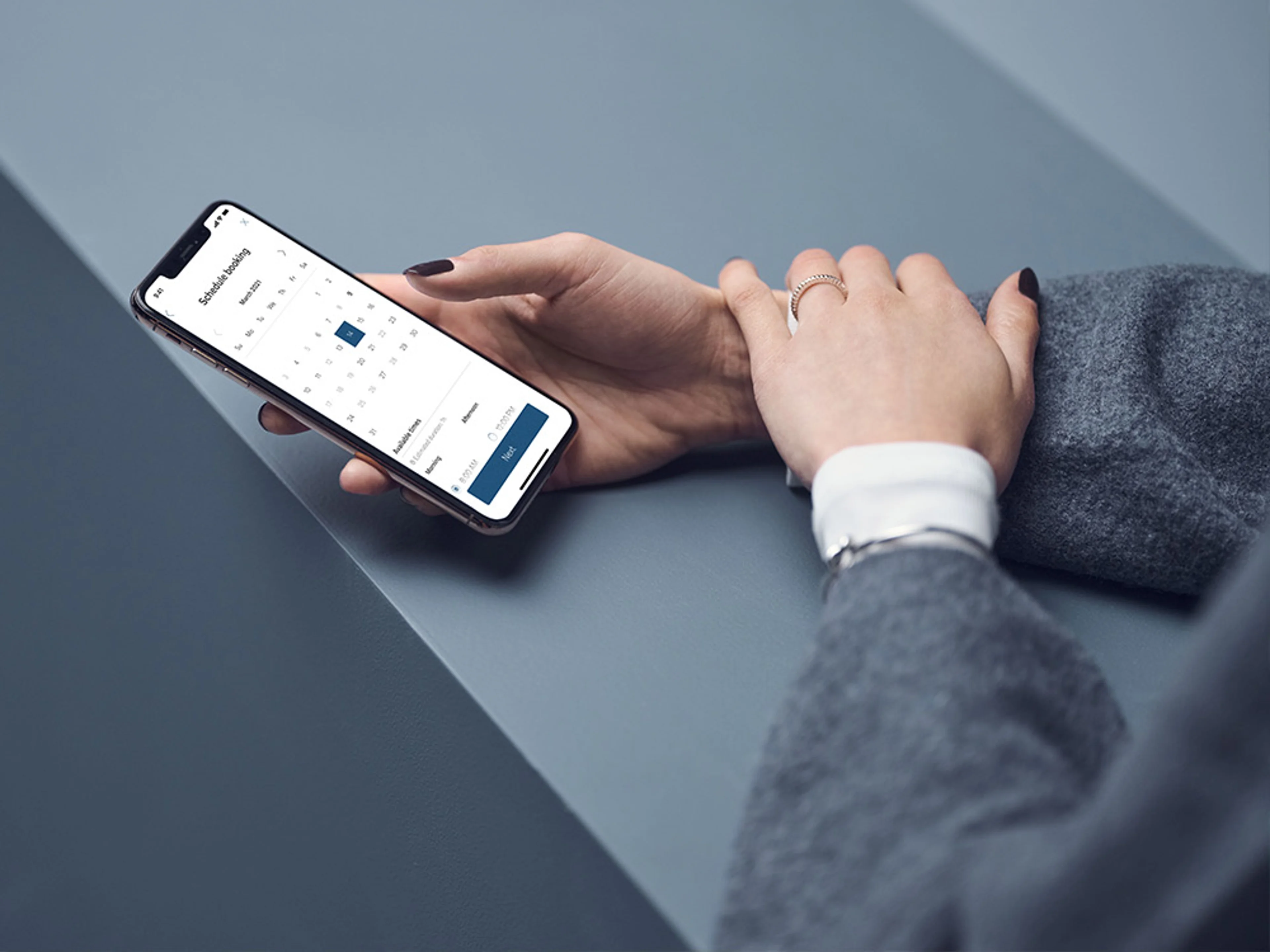 Gros plan sur des mains utilisant un smartphone avec l'application Volvo Cars.
