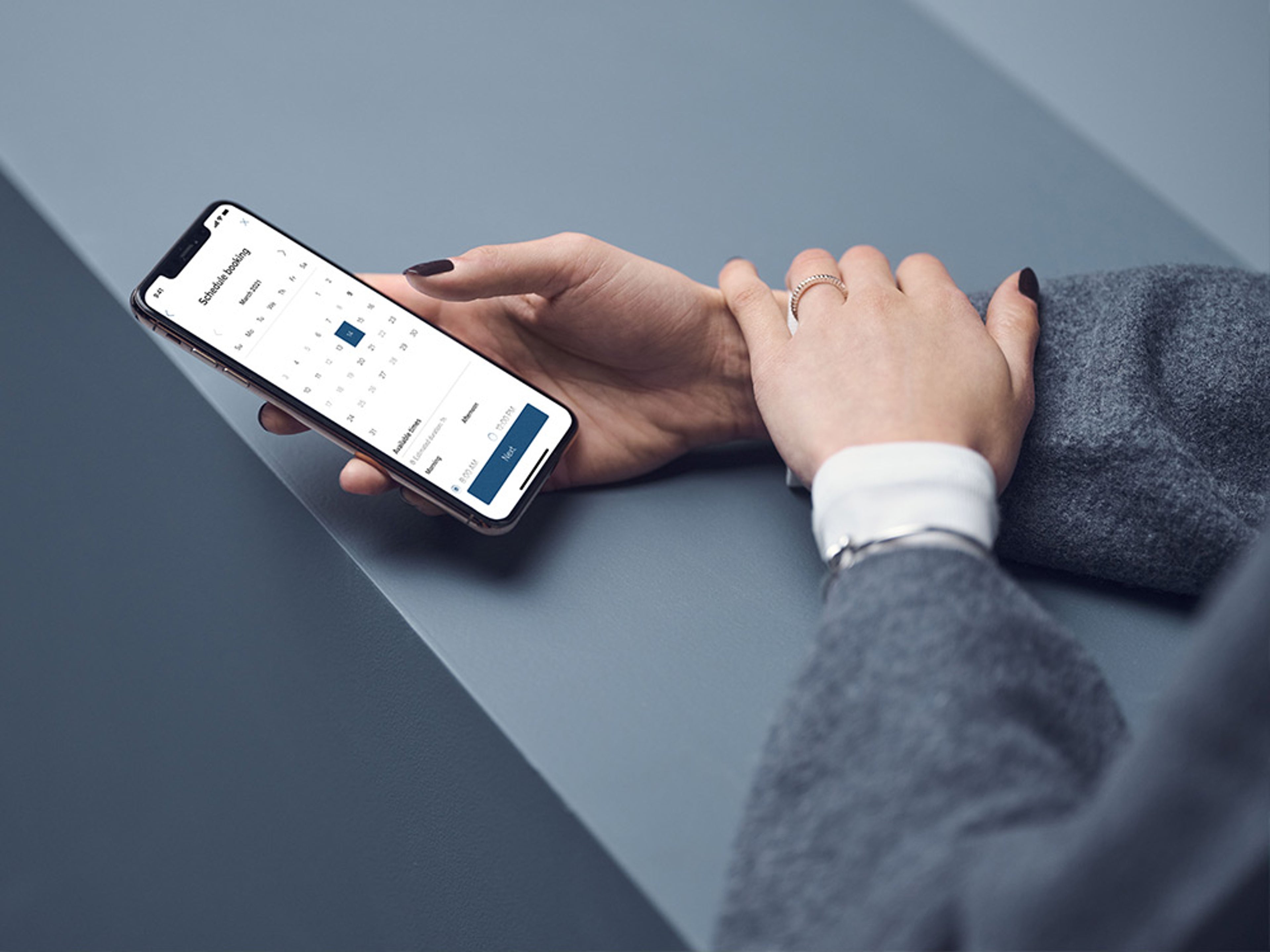 Gros plan sur des mains utilisant un smartphone avec l'application Volvo Cars.