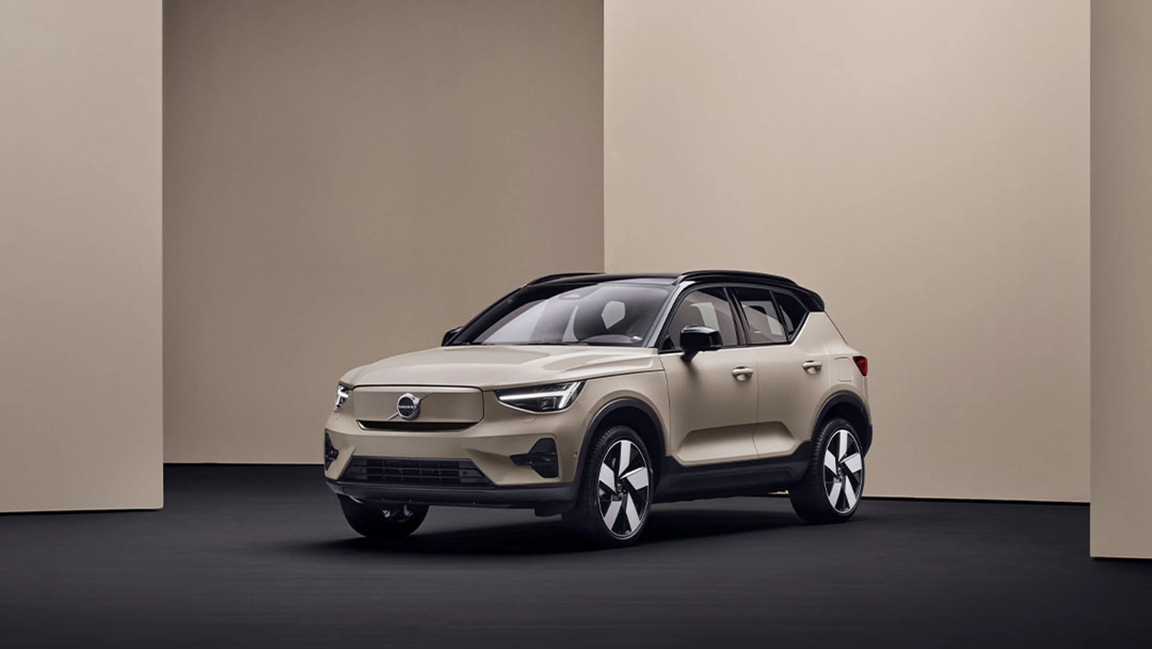 Volvo EX40 beige garé dans une pièce minimaliste aux murs beiges et sol noir