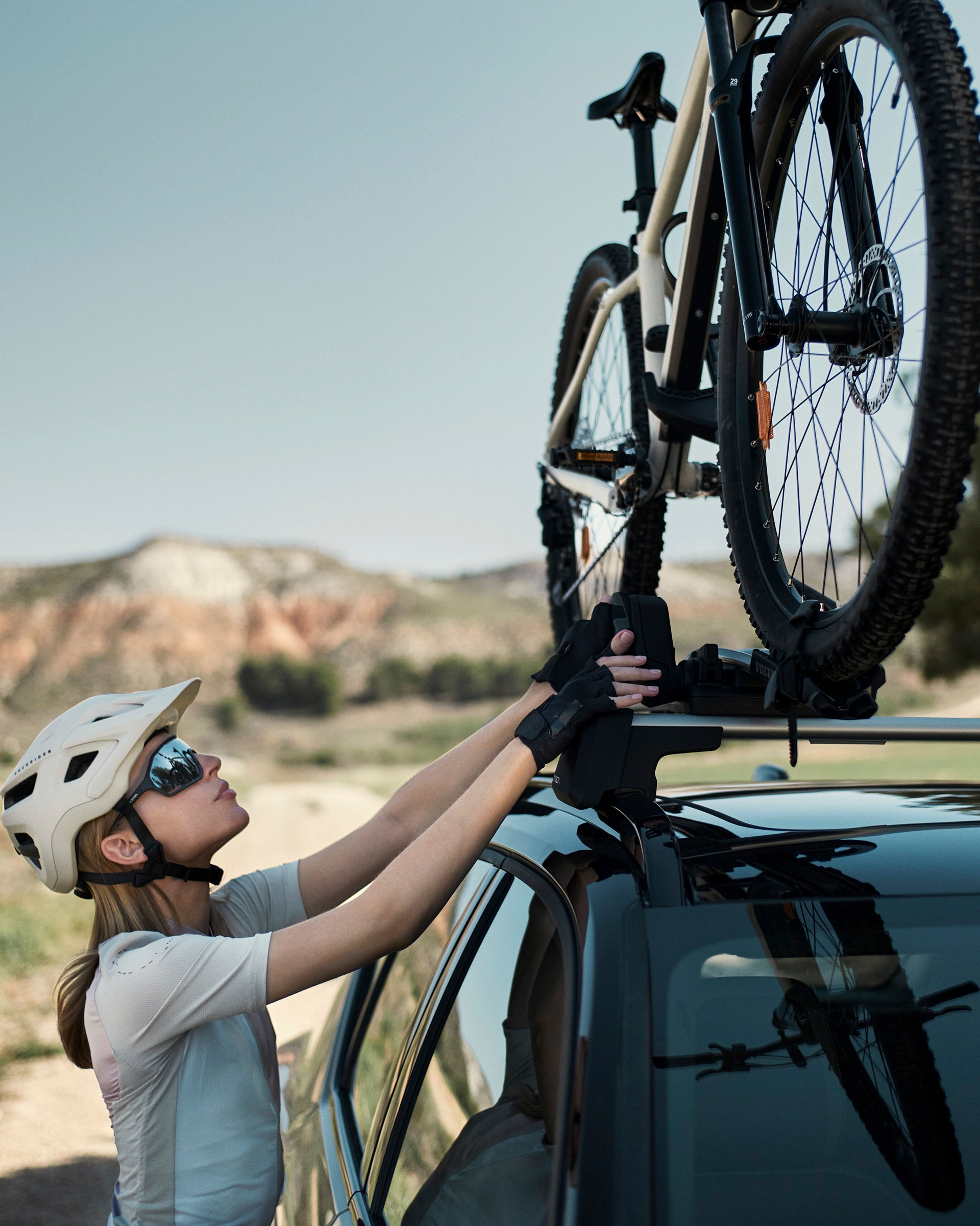 Una chica colocando un accesorio de techo en un Volvo