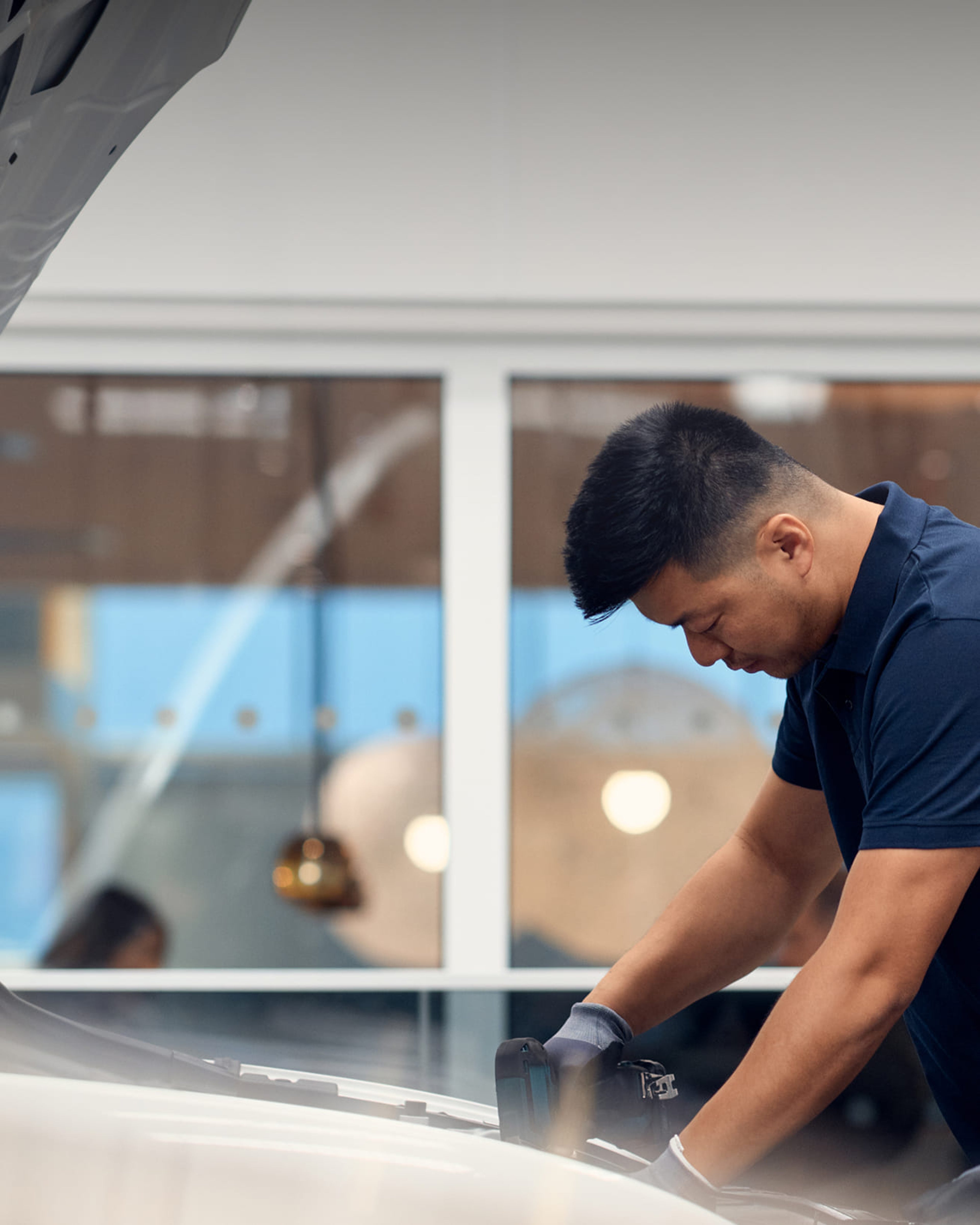 En volvo servicetekniker som tittar ner i huven på bilen