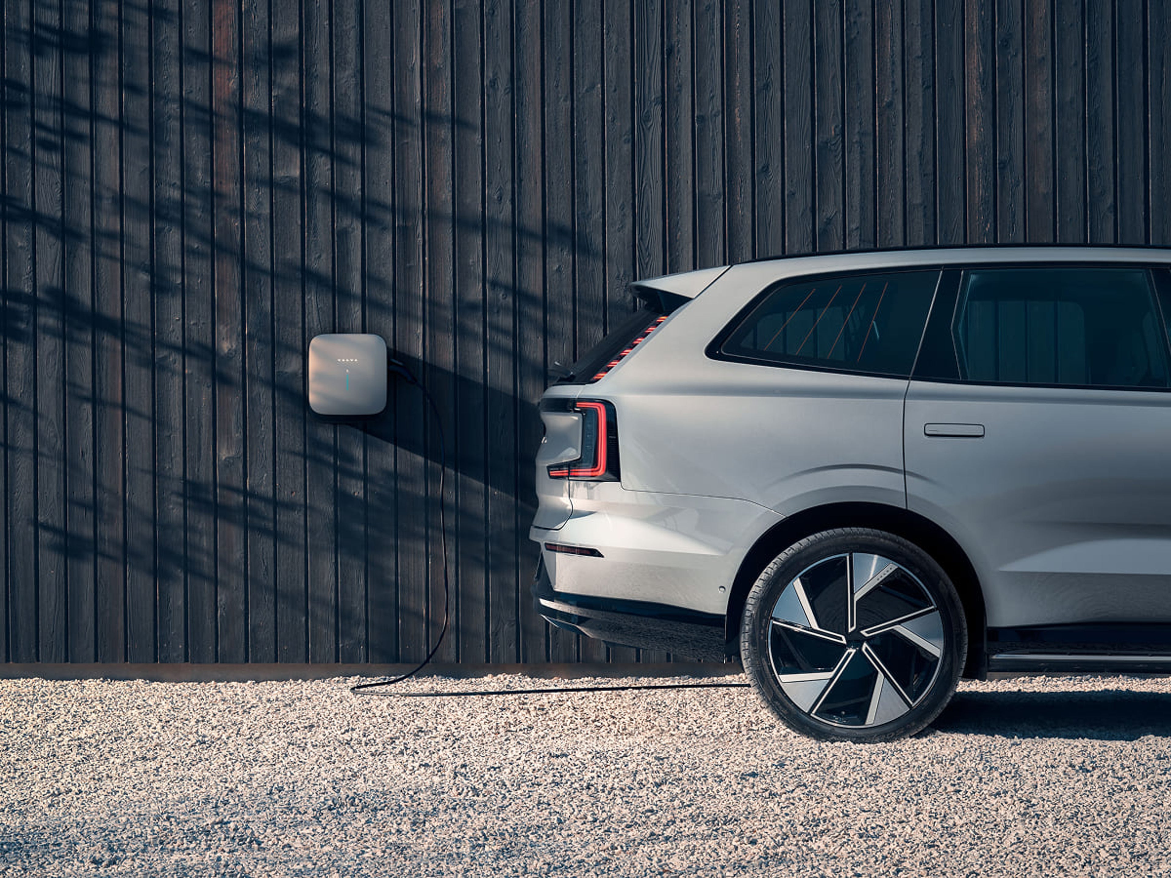 Volvo elbil som laddas vid elbox på en husfasad