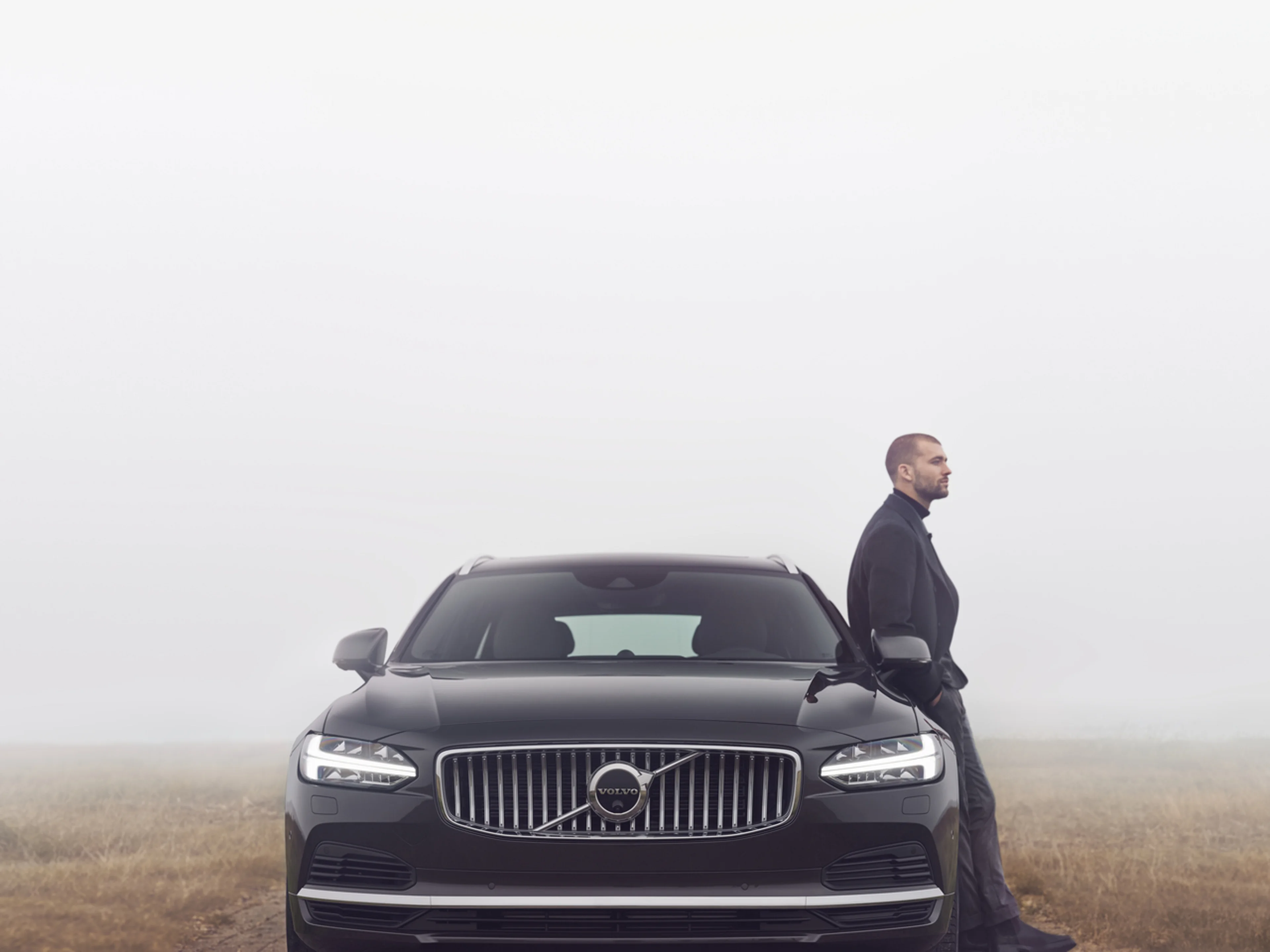 Mann lener seg på Volvo
