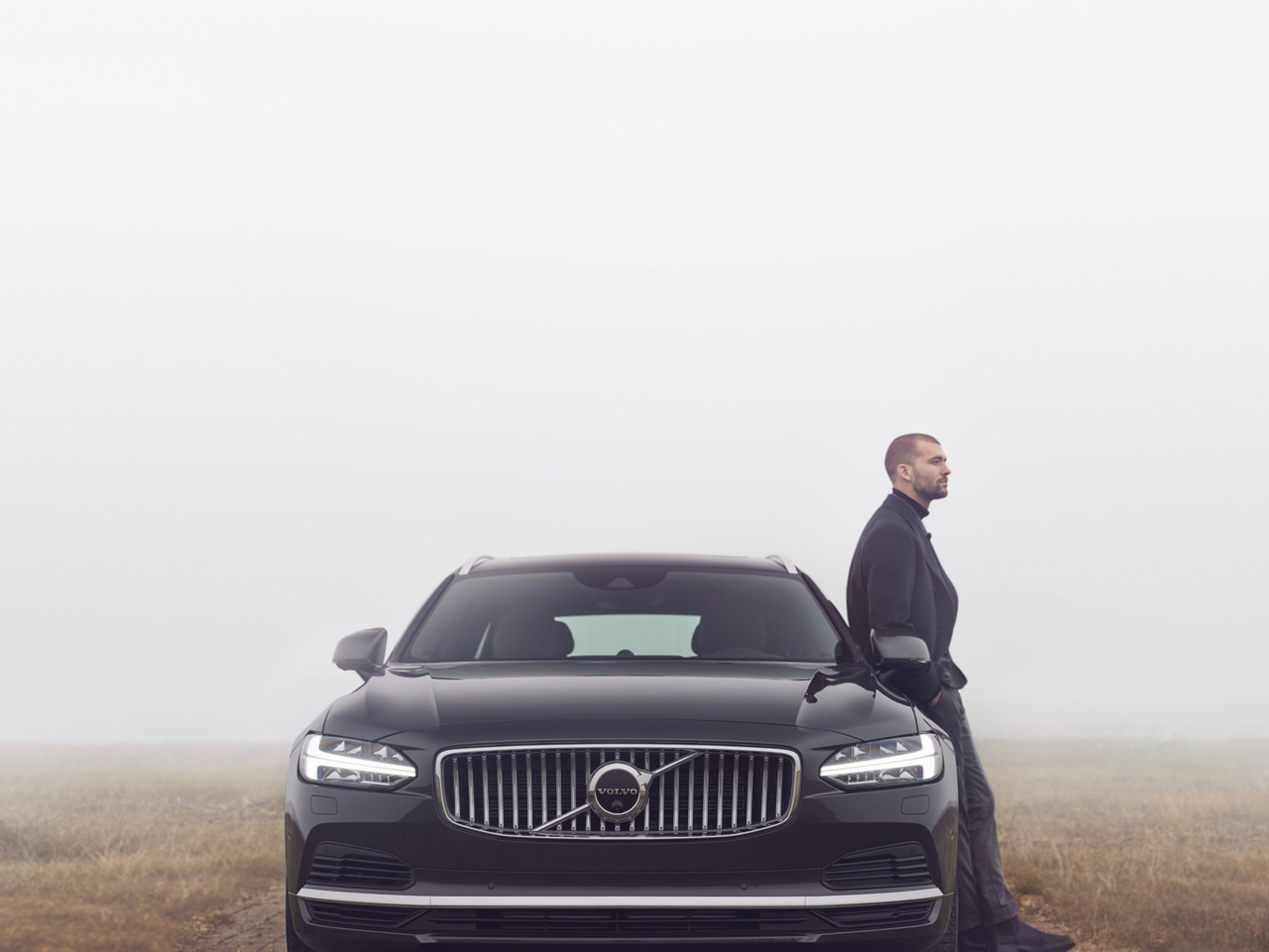 Mann lener seg på Volvo