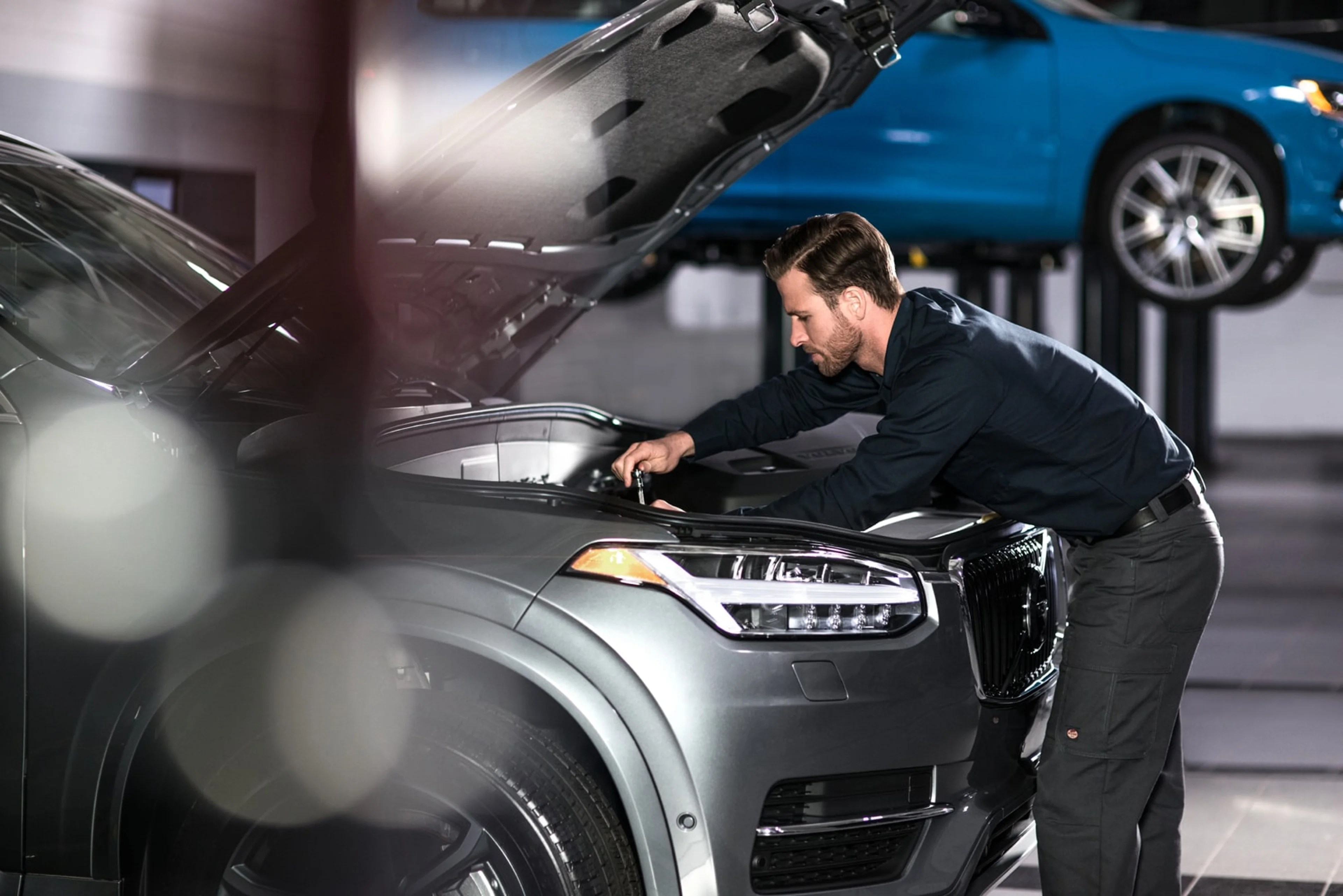 Automechanik v garáži opravuje Volvo XC60 v motorovej časti