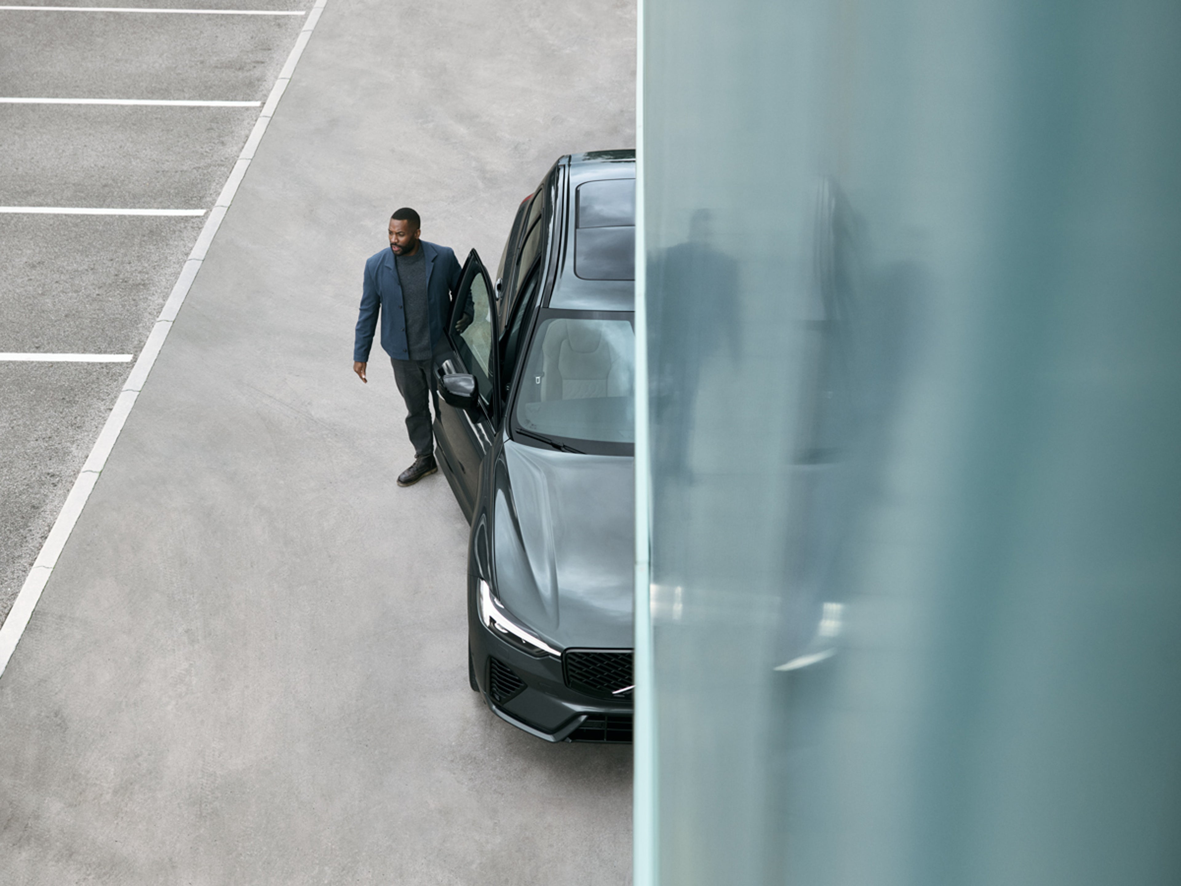 Man vid en Volvo med öppen passagerardörr.