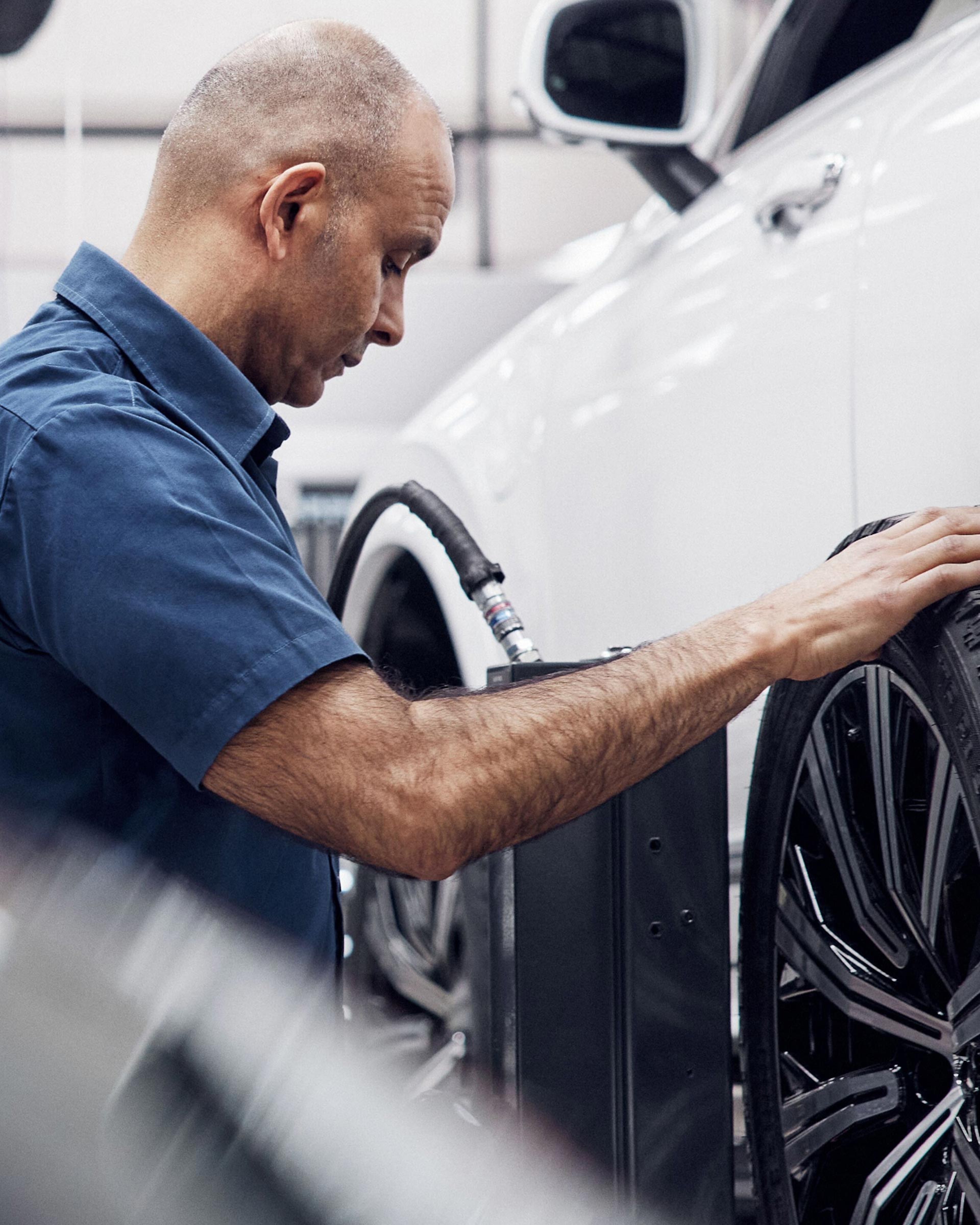 Ein Volvo Mechaniker montiert einen neuen Reifen an einen Volvo XC90.