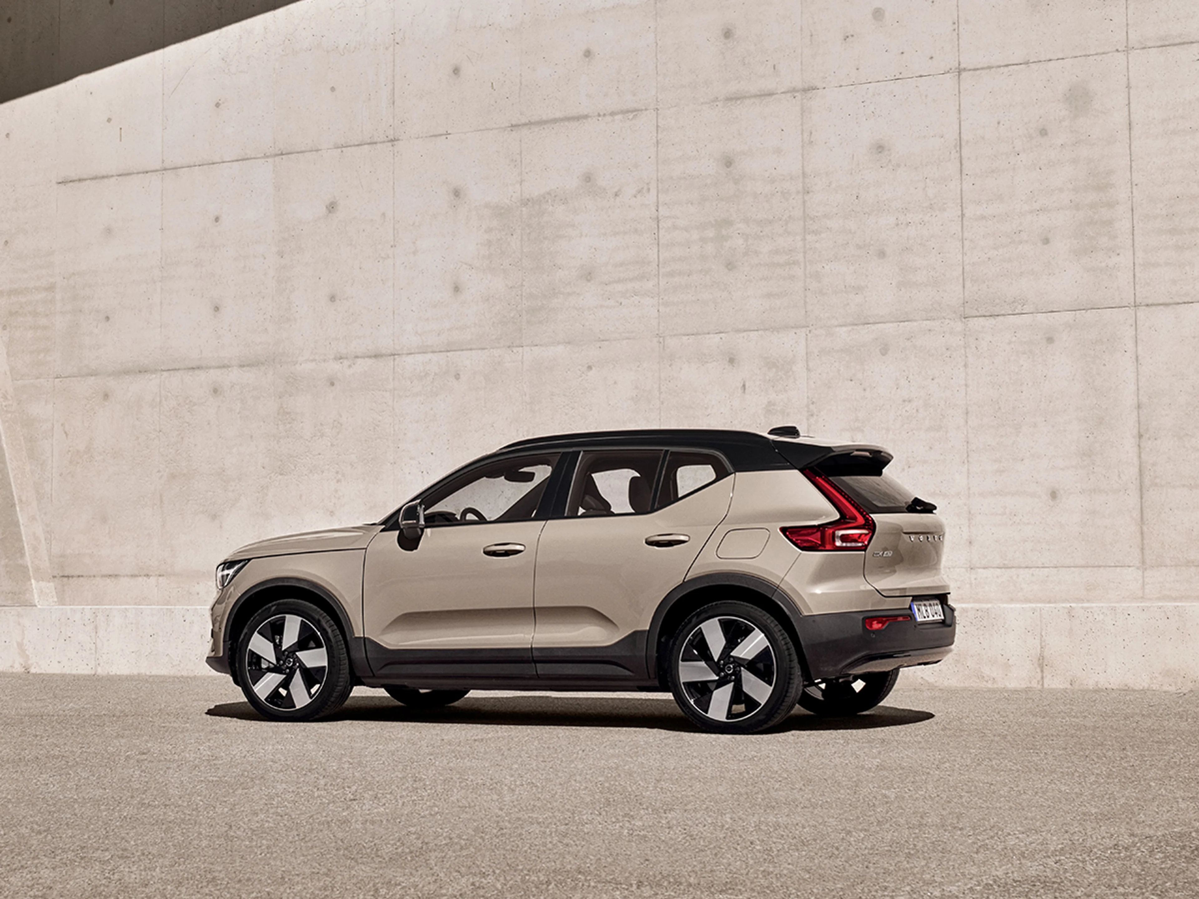 Volvo EX40 från sidan parkerad vid betongvägg