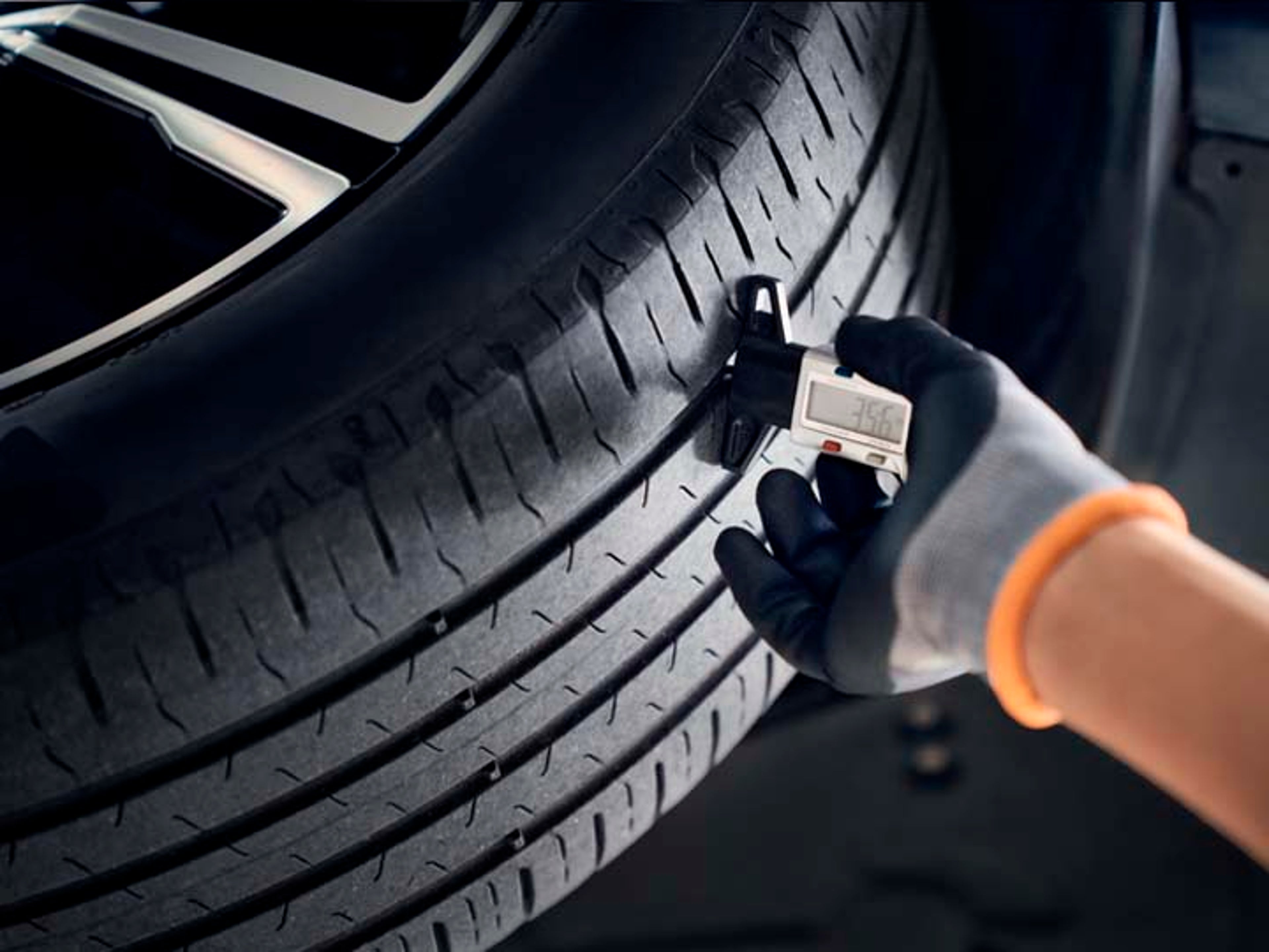 Una mano haciendo mediciones sobre un neumático Volvo