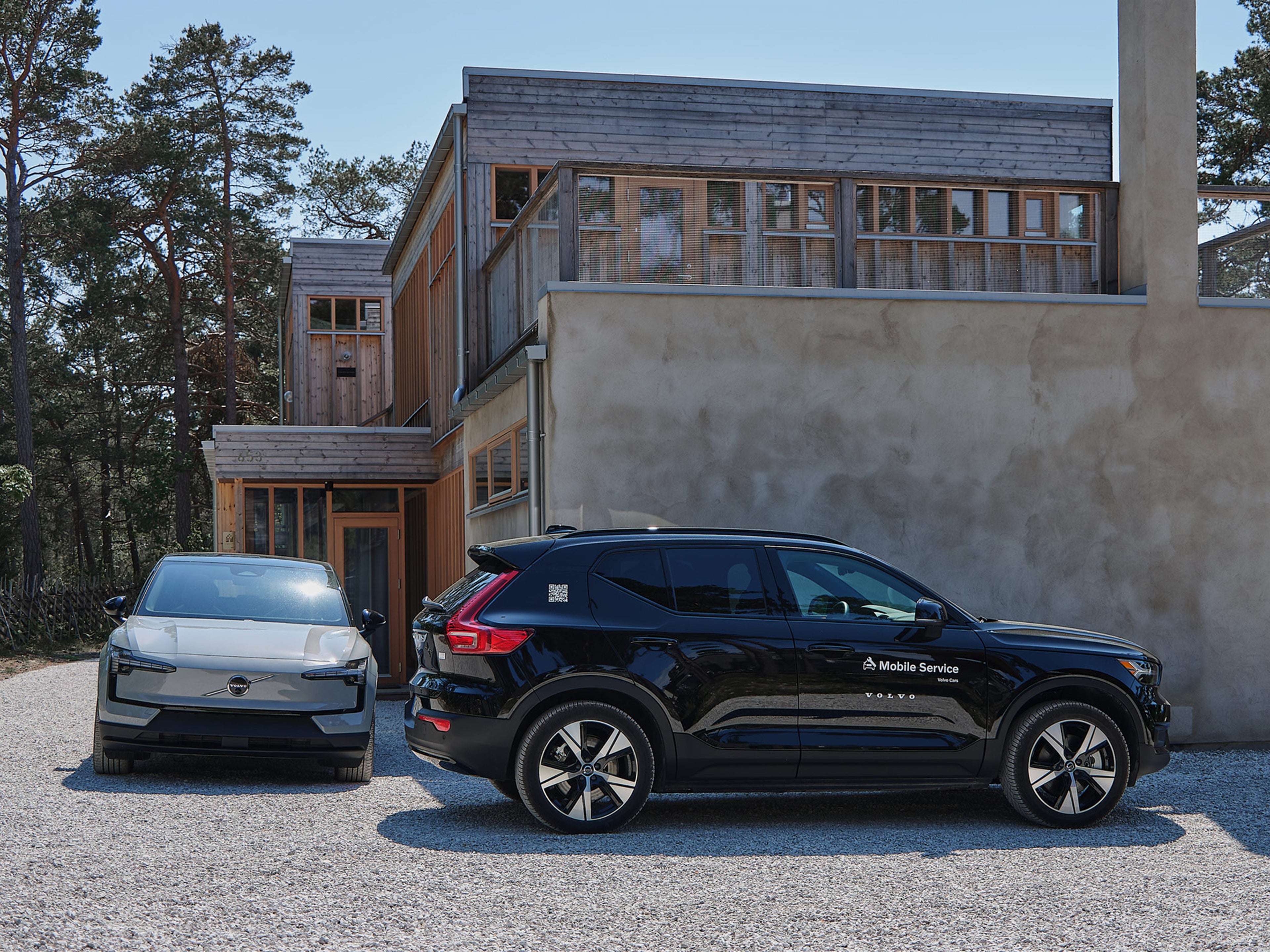 Volvo EX30 ja Volvo Mobile Service huoltoauto pihatielle pysäköitynä.