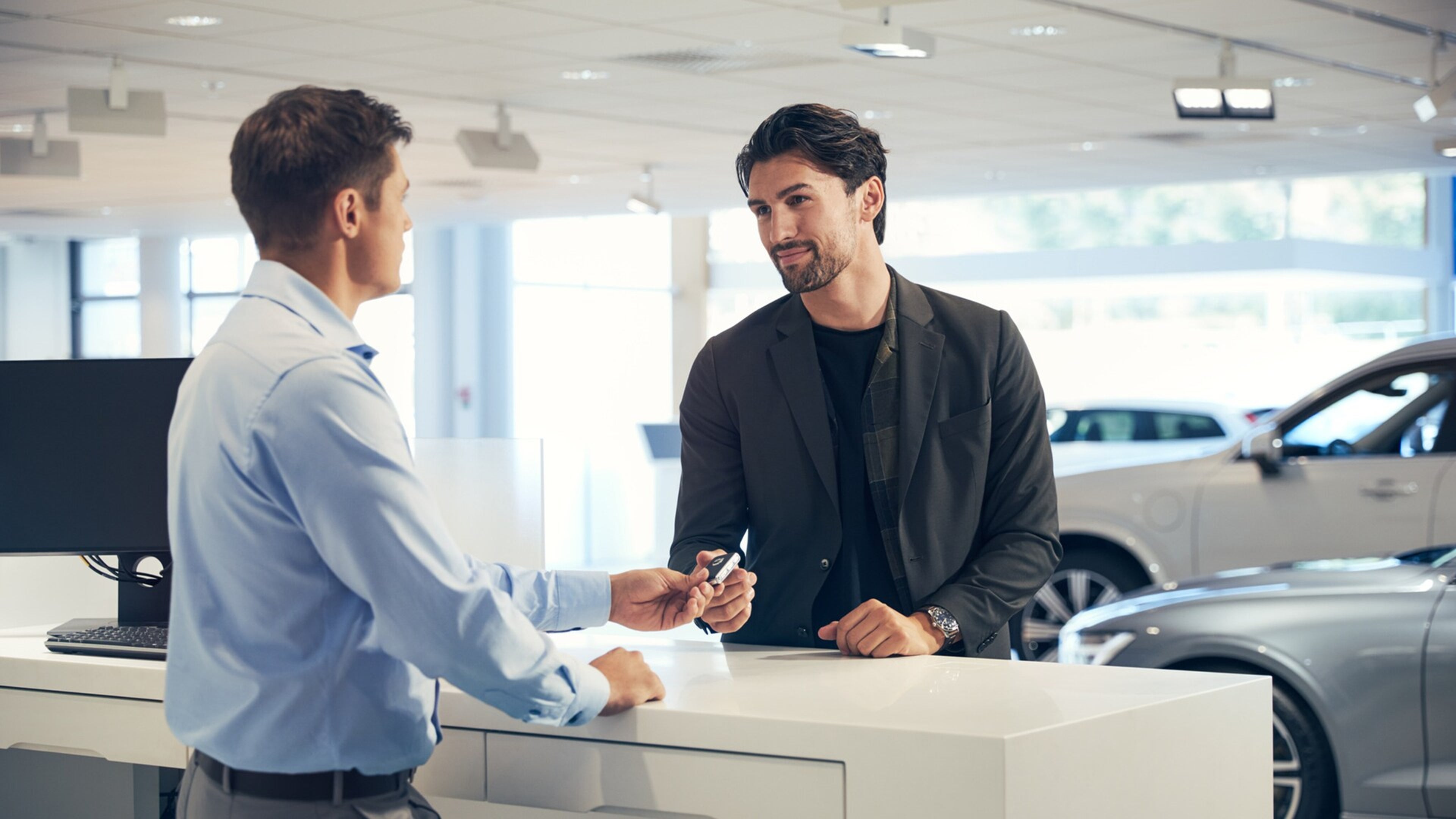 Egy férfi átveszi Volvója kulcsát egy Volvo márkaszervizben