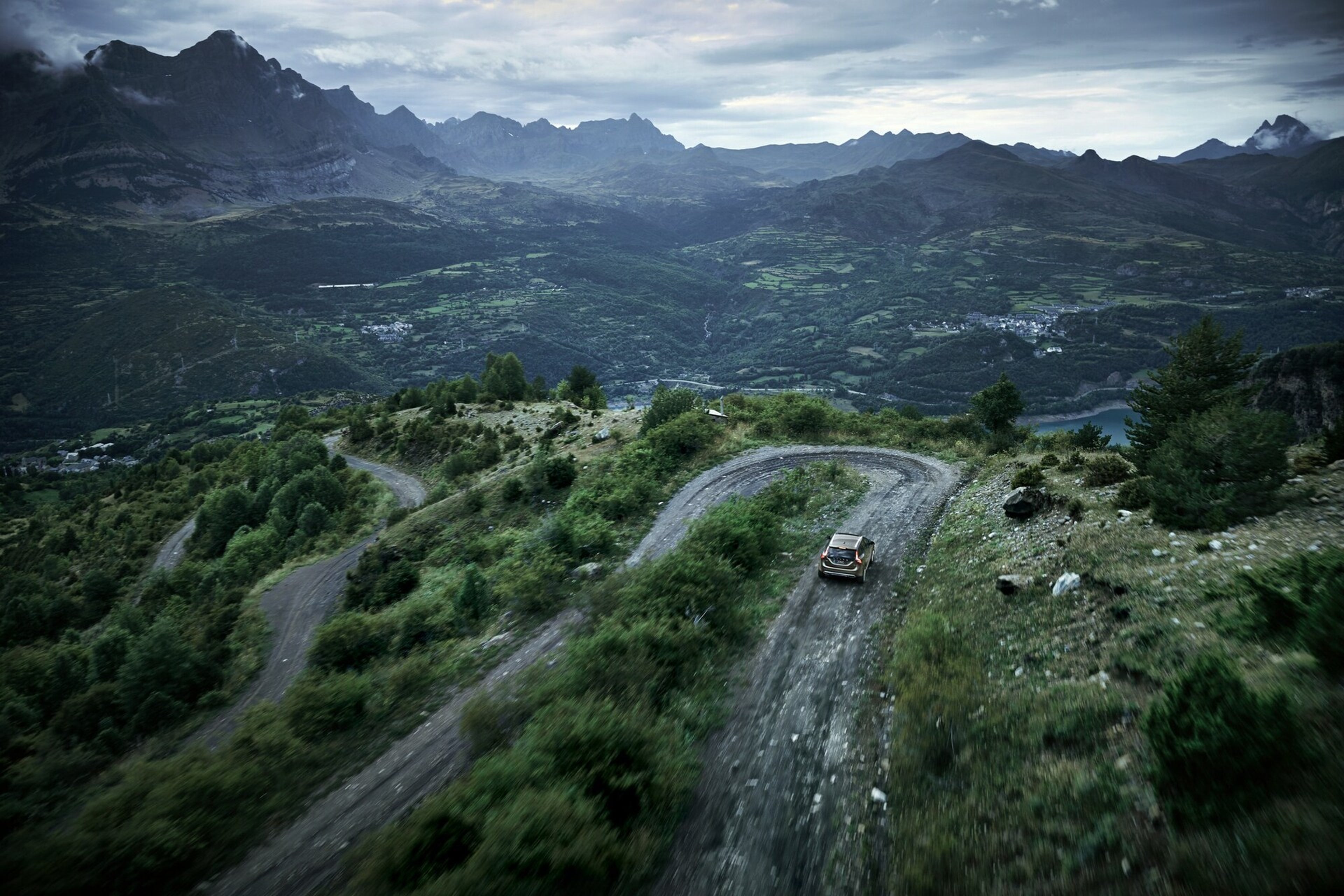 Távoli kép egy Volvóról, amint egy hegyi szerpentines úton halad