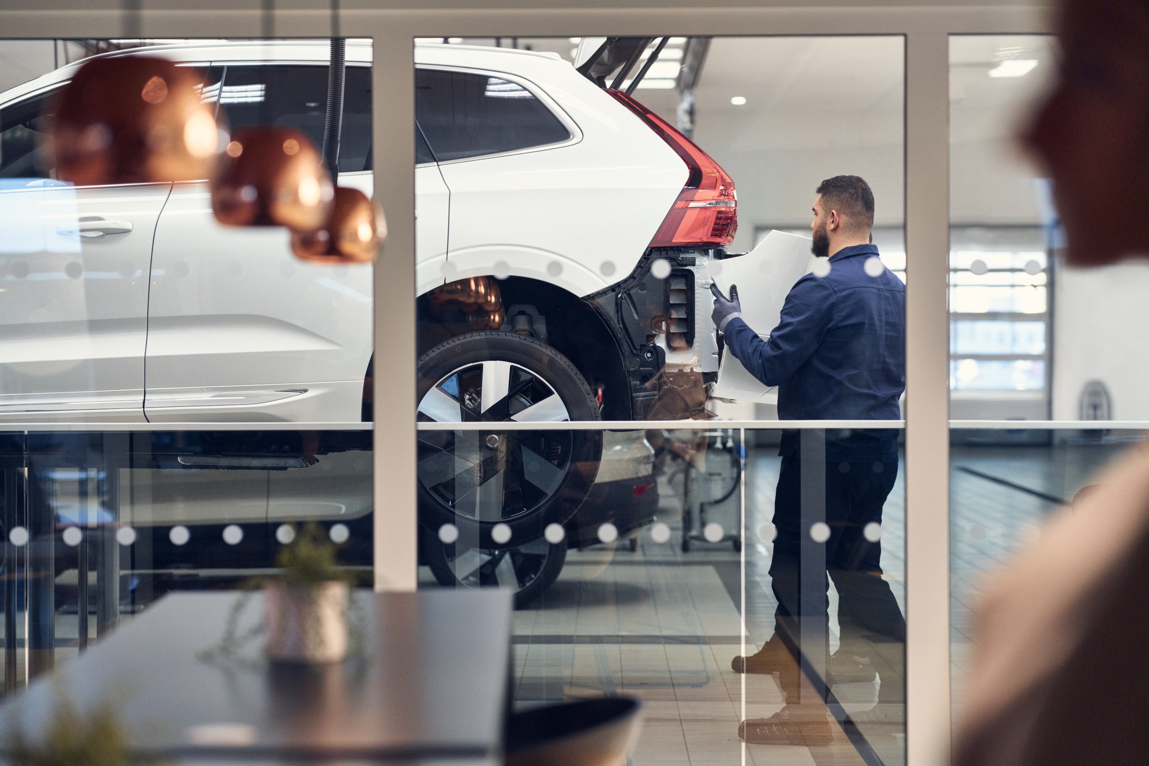 Volvo technician pointing at car in showroom