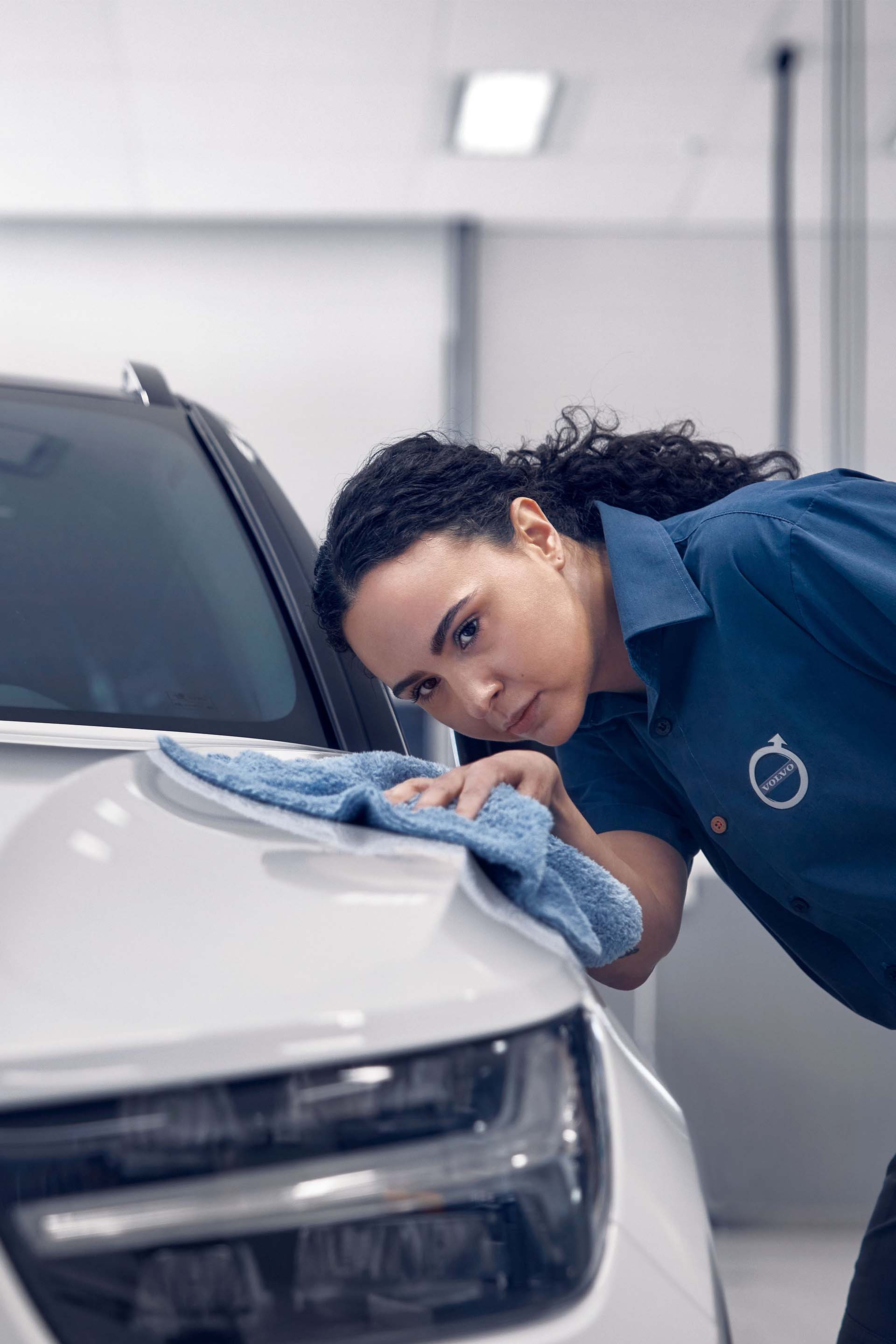 Dame som tørker over ett bilpanser