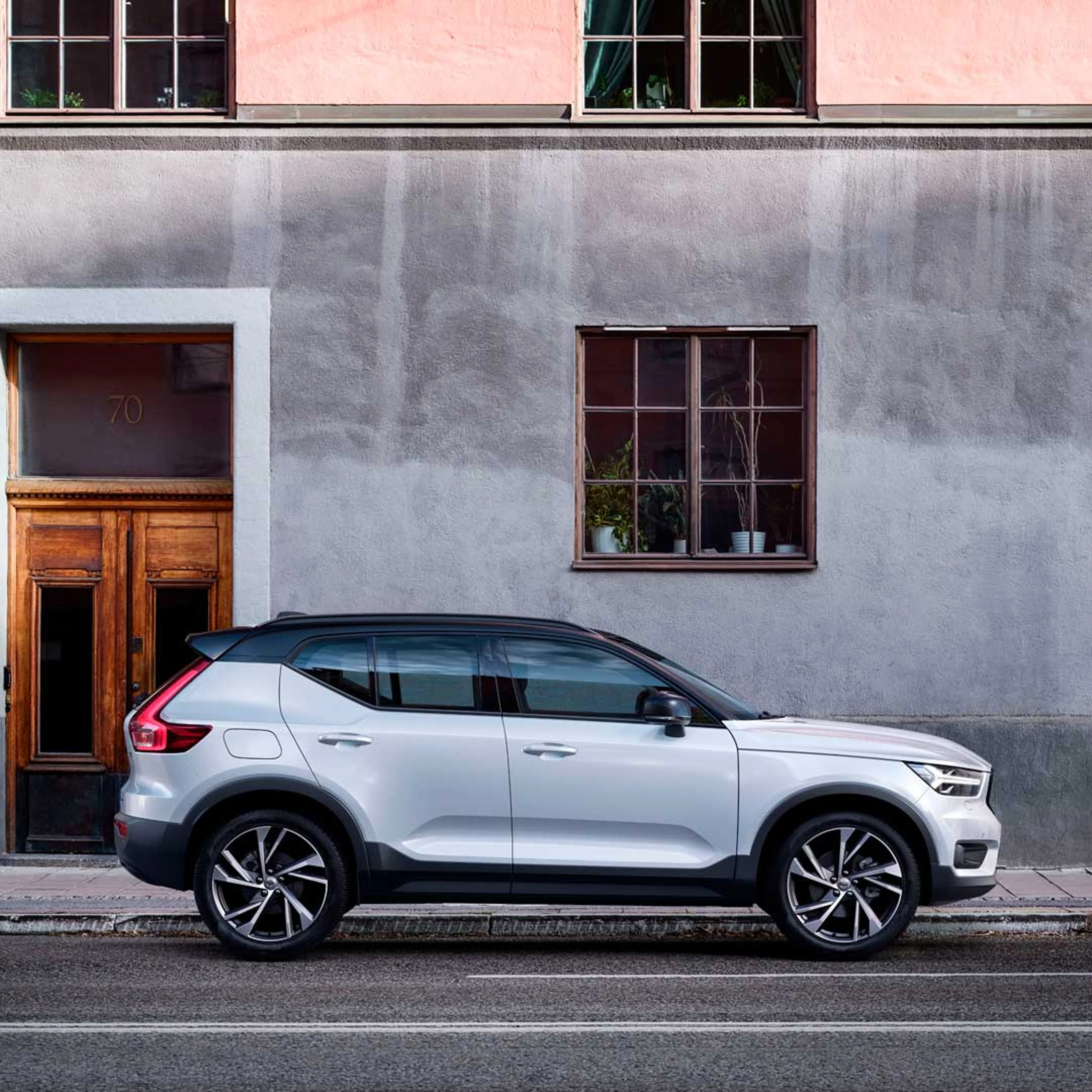 Un Volvo XC40 blanco con techo negro estacionado en la ciudad.