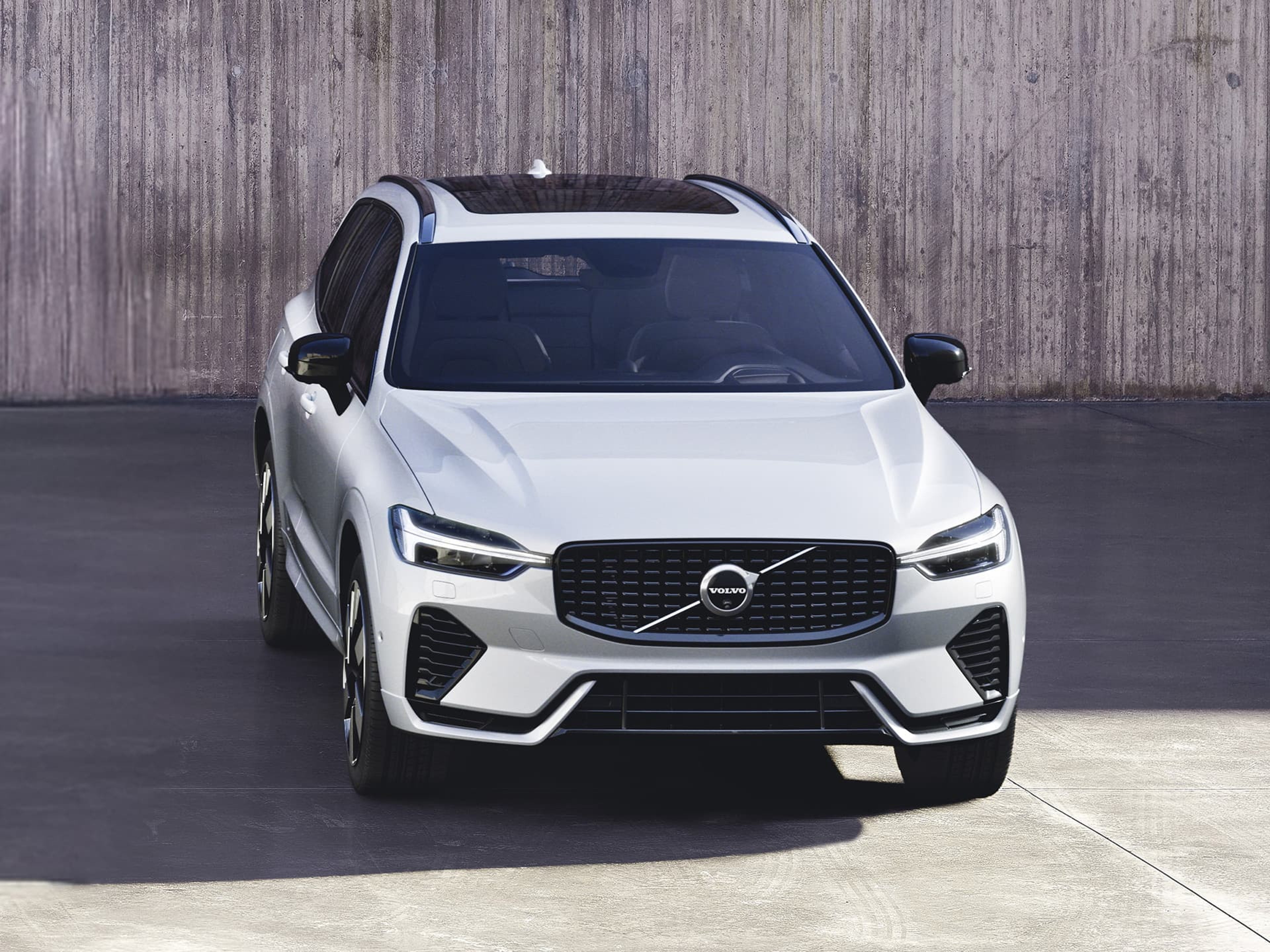 Vue de face d'un SUV Volvo XC60 de couleur blanche, garé devant un mur en béton.