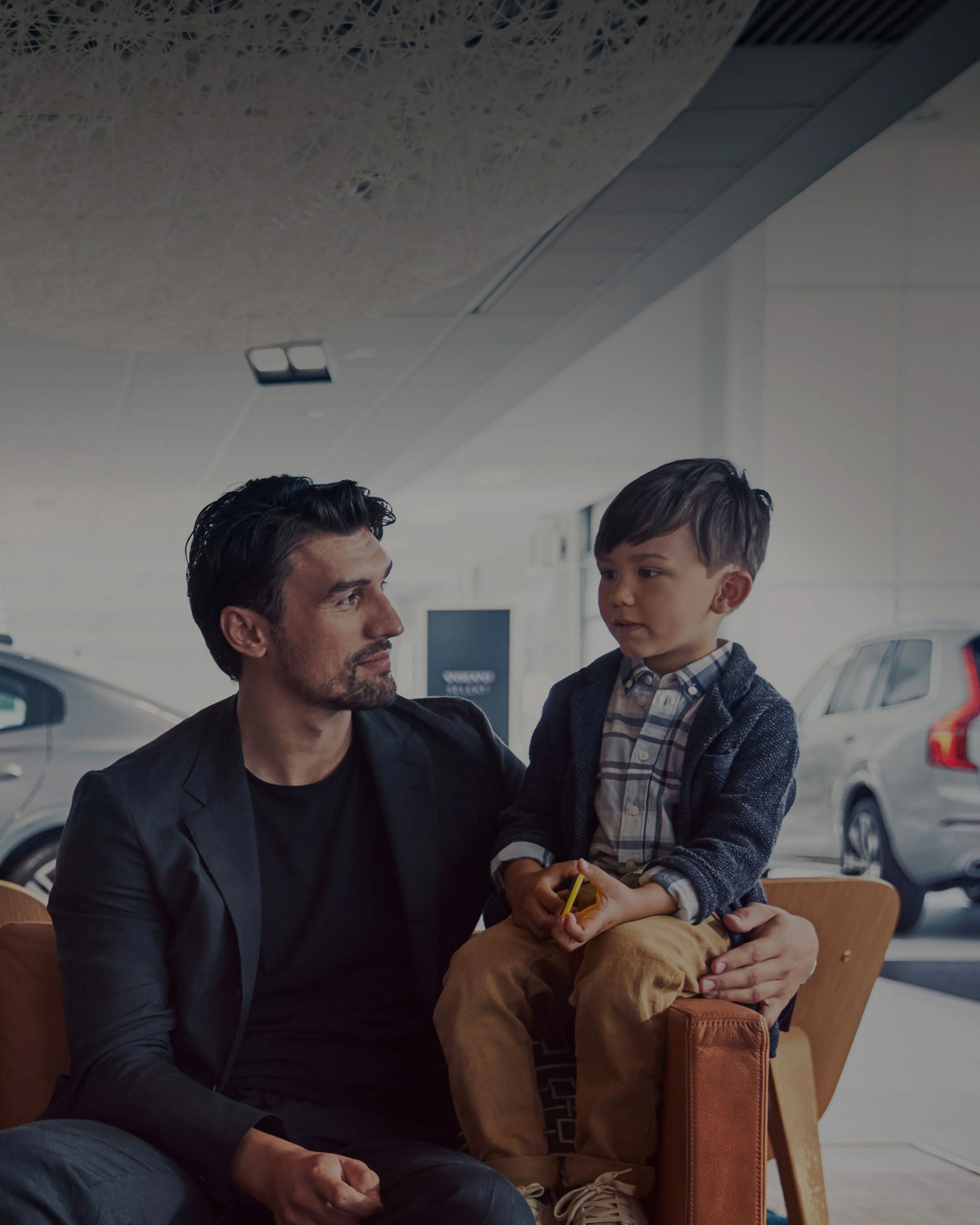 Un père et son fils dans une salle d'exposition, symbolisant le service personnalisé et la confiance que Volvo offre.