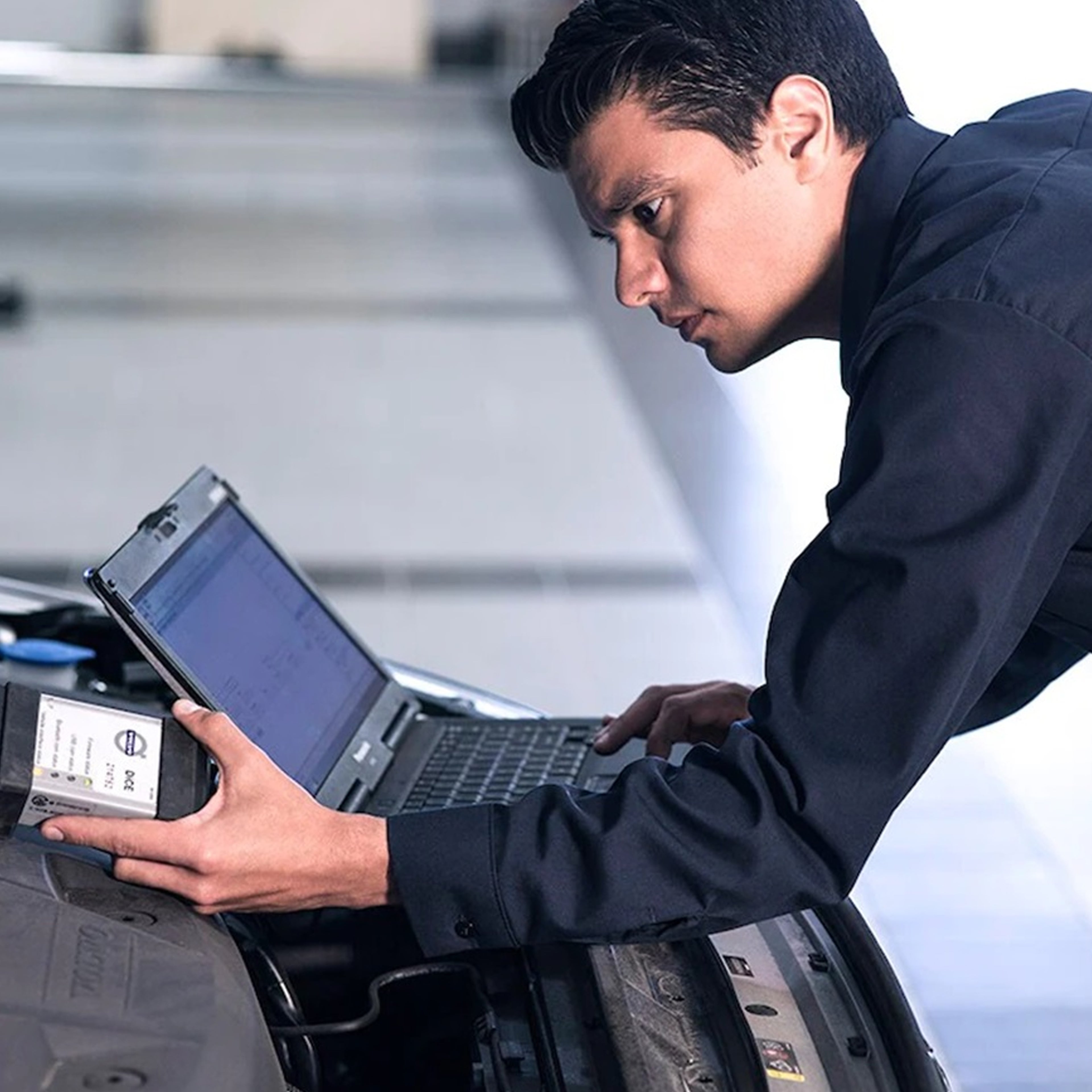 Ein Volvo Techniker nutzt einen Laptop zur Kalibrierung einer Glasscheibe.