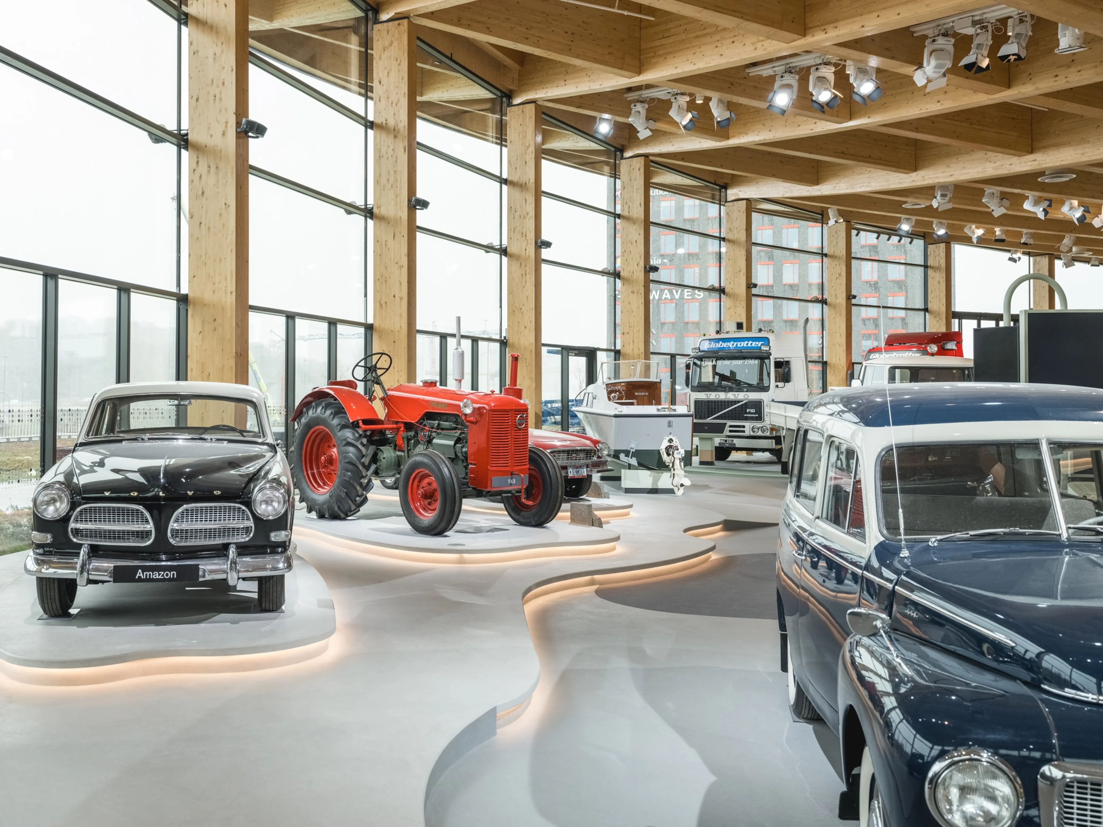 Photo of interior of World of Volvo showing classic Volvo Cars and farm equipment