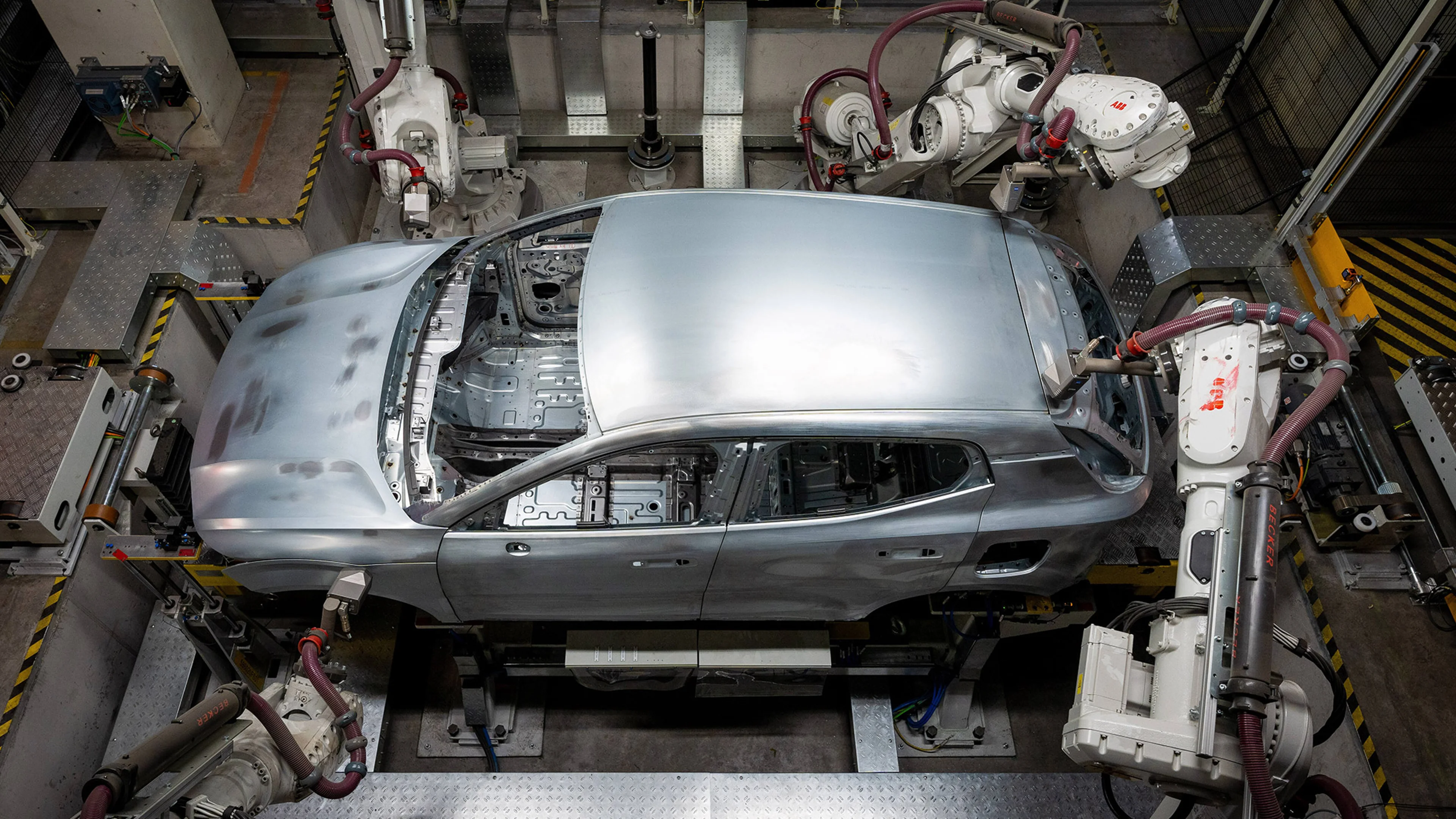 Volvo EX30 täyssähköauton kori robottien käsittelyssä Gentin tehtaan tuotantolinjalla.