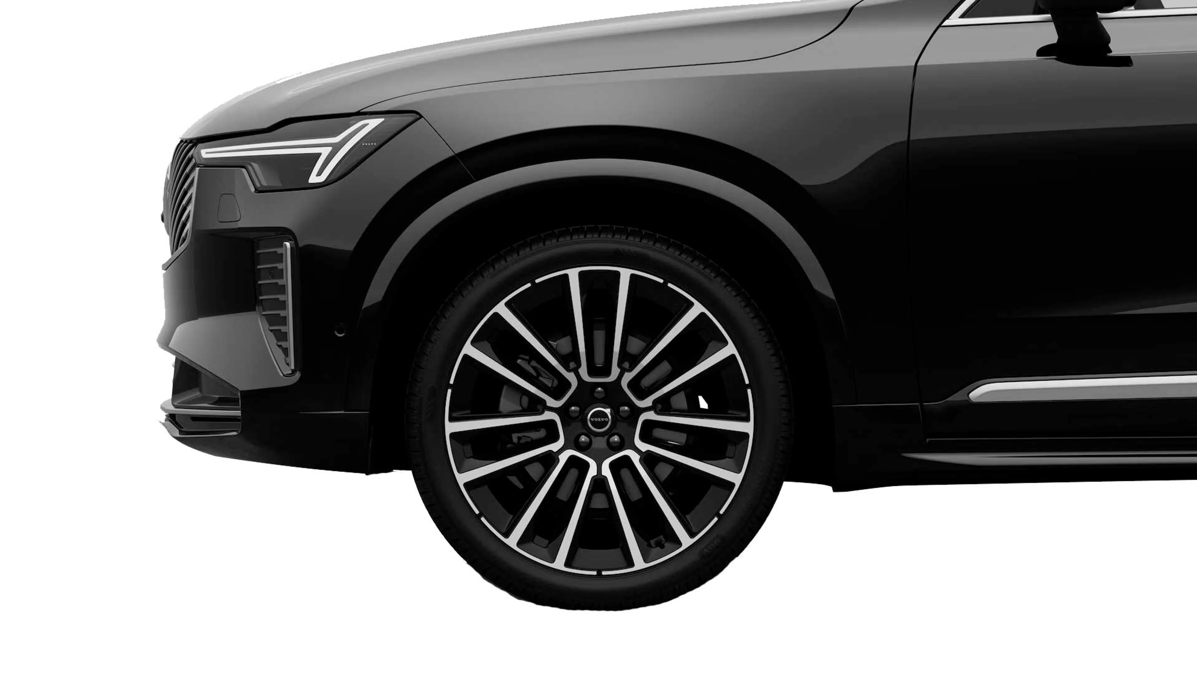 Close-up af en elegant sort Volvo Xc90 bil med et fremtrædende forhjul med detaljeret alufælg. Køretøjet udstråler et moderne og luksuriøst præg.