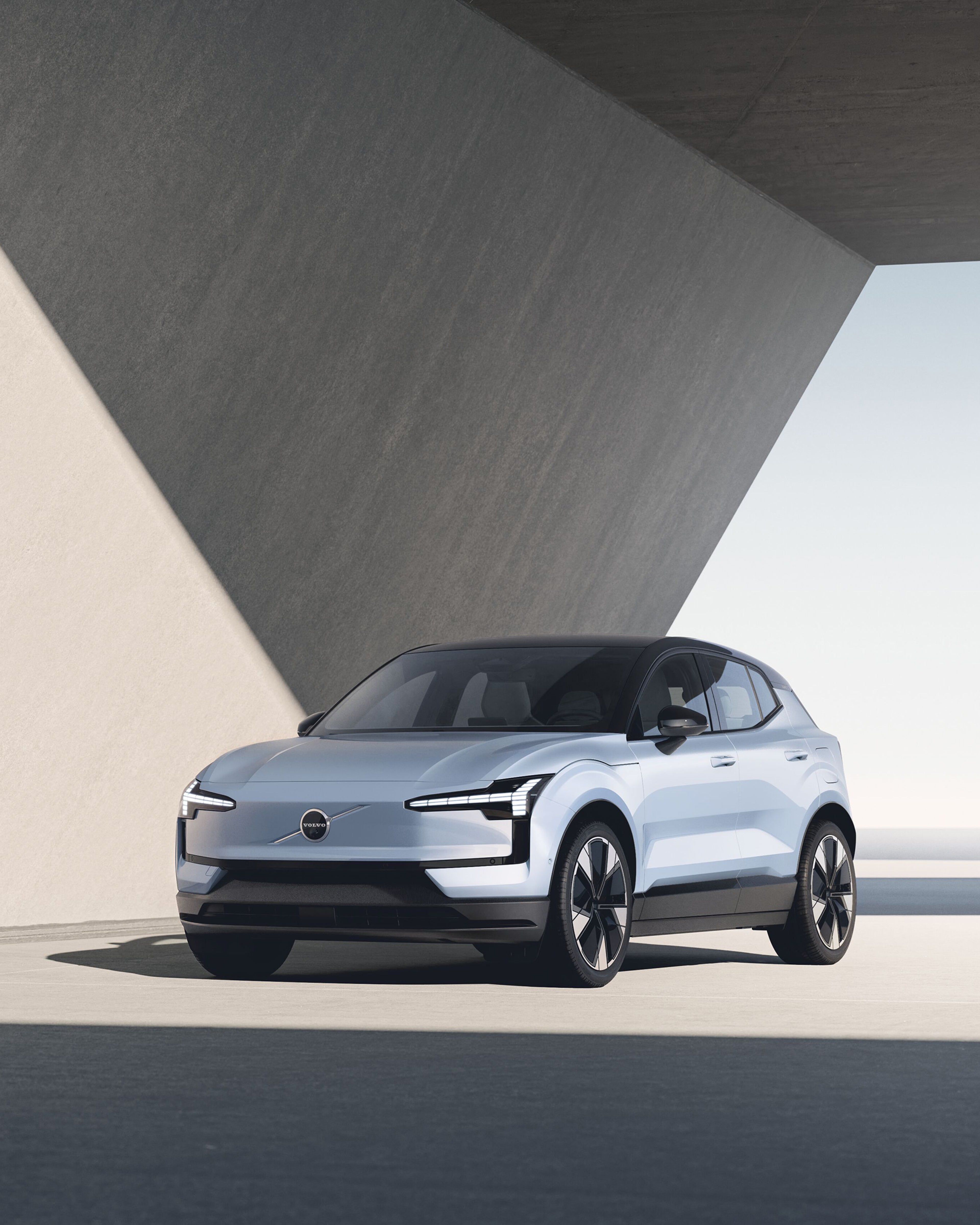 Cloud Blue -värinen Volvo EX30 täyssähköauto etuviistosta kuvattuna hiekanvärisellä taustalla.