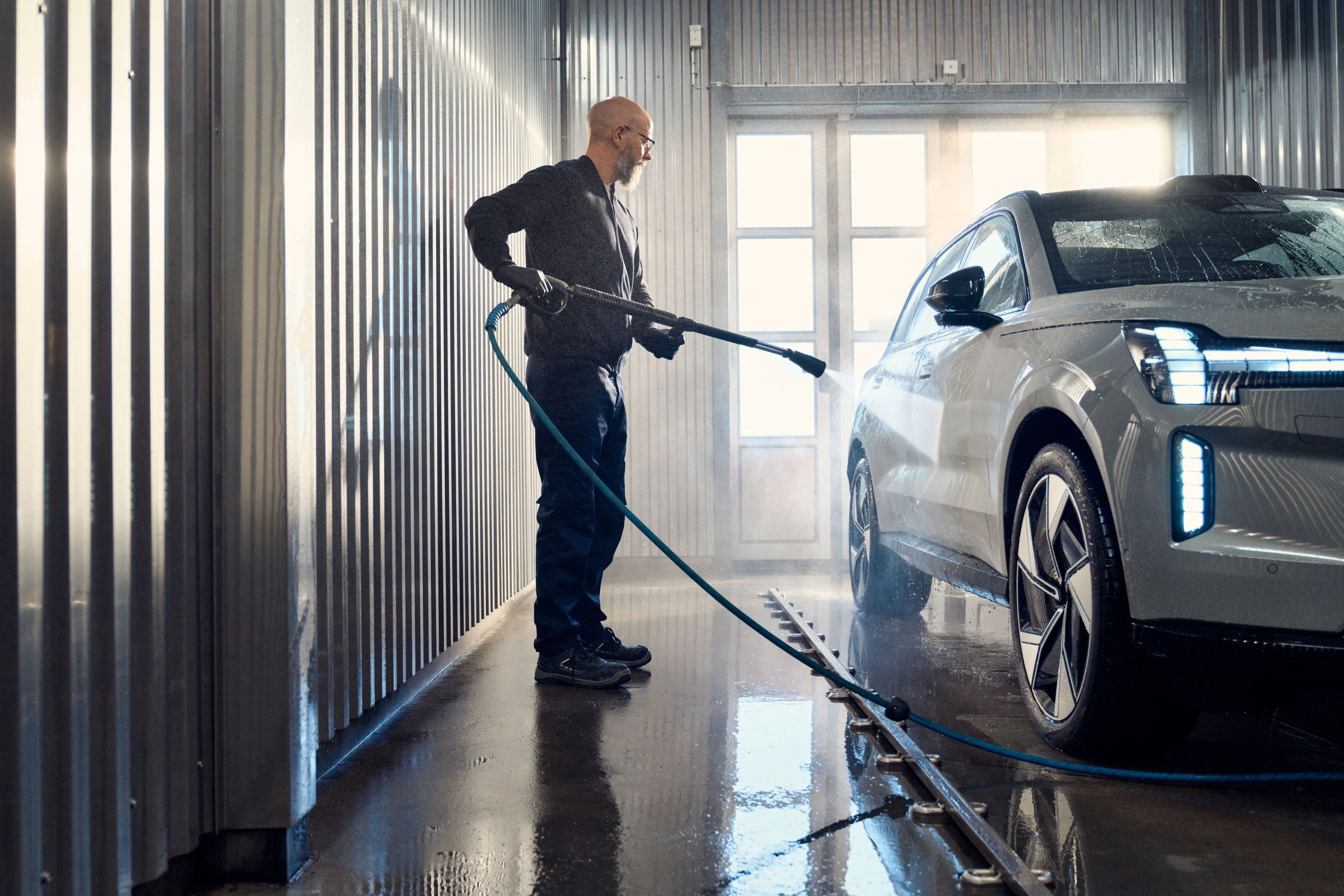 Volvo in de carwash wordt schoongemaakt door man