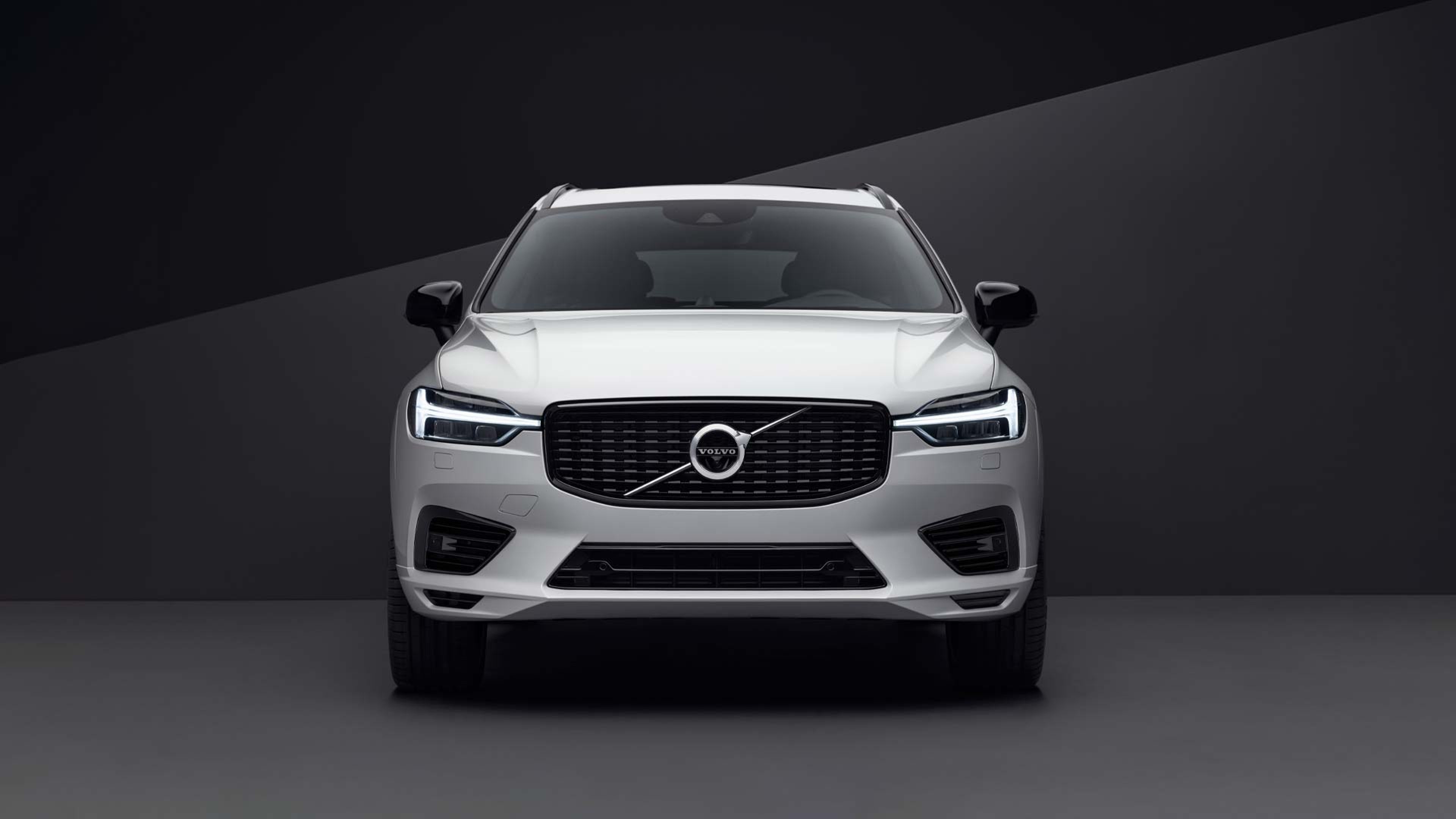 Beli Volvo SUV na temnem ozadju.