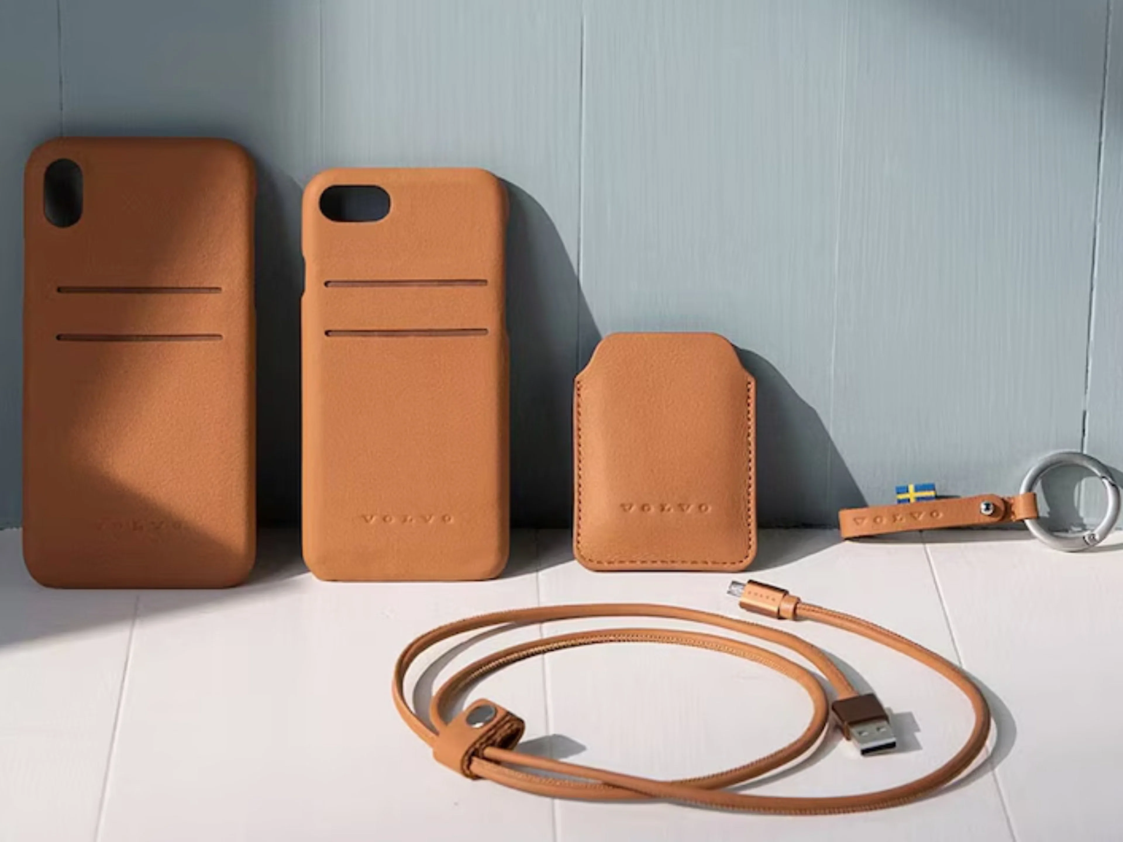 Diverses Volvo Lederzubehör, wie Handy Cases, Schlüsselring und Charging-Kabel.