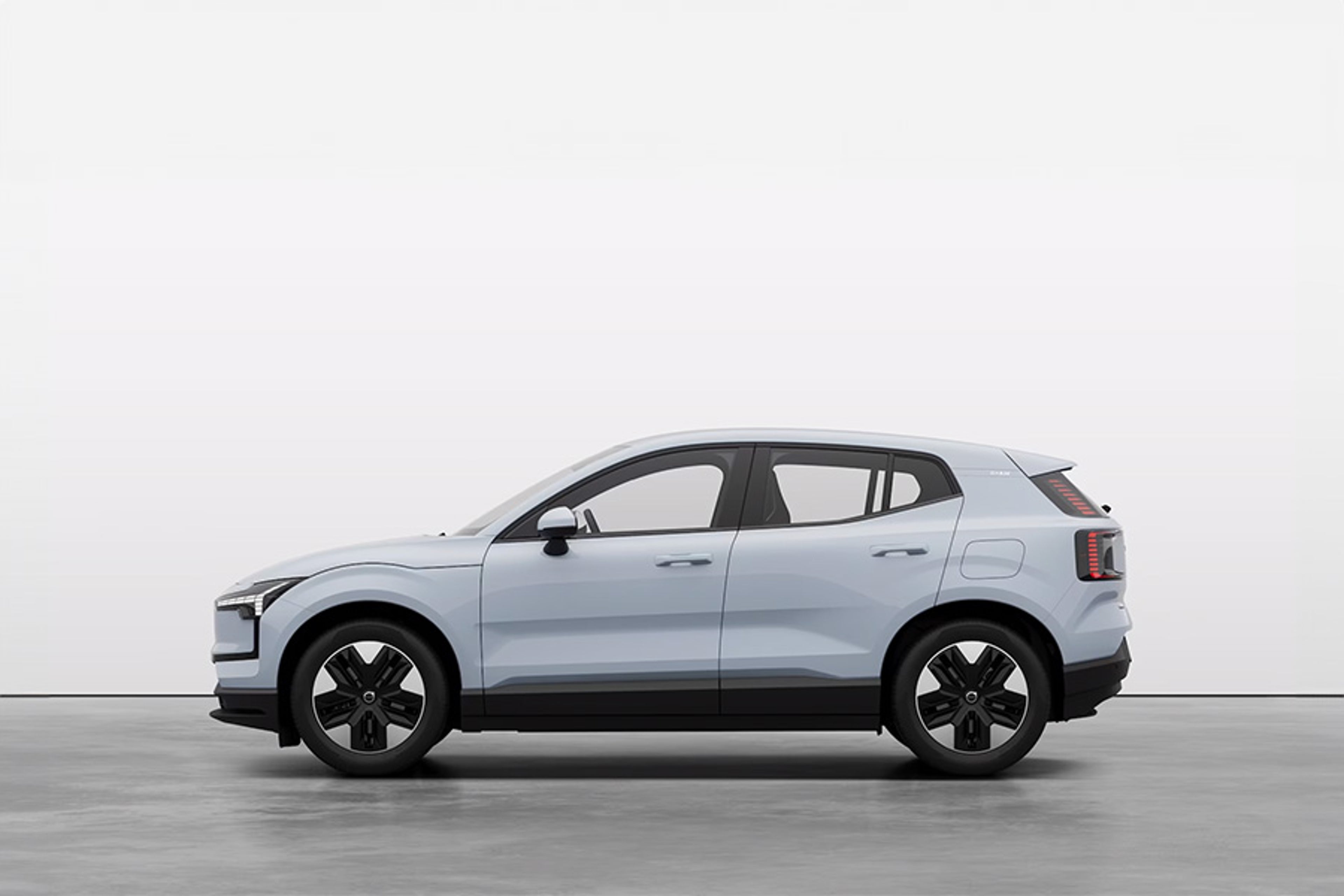 Bočni prikaz bijelog električnog SUV-a Volvo EX30 u studijskom okruženju