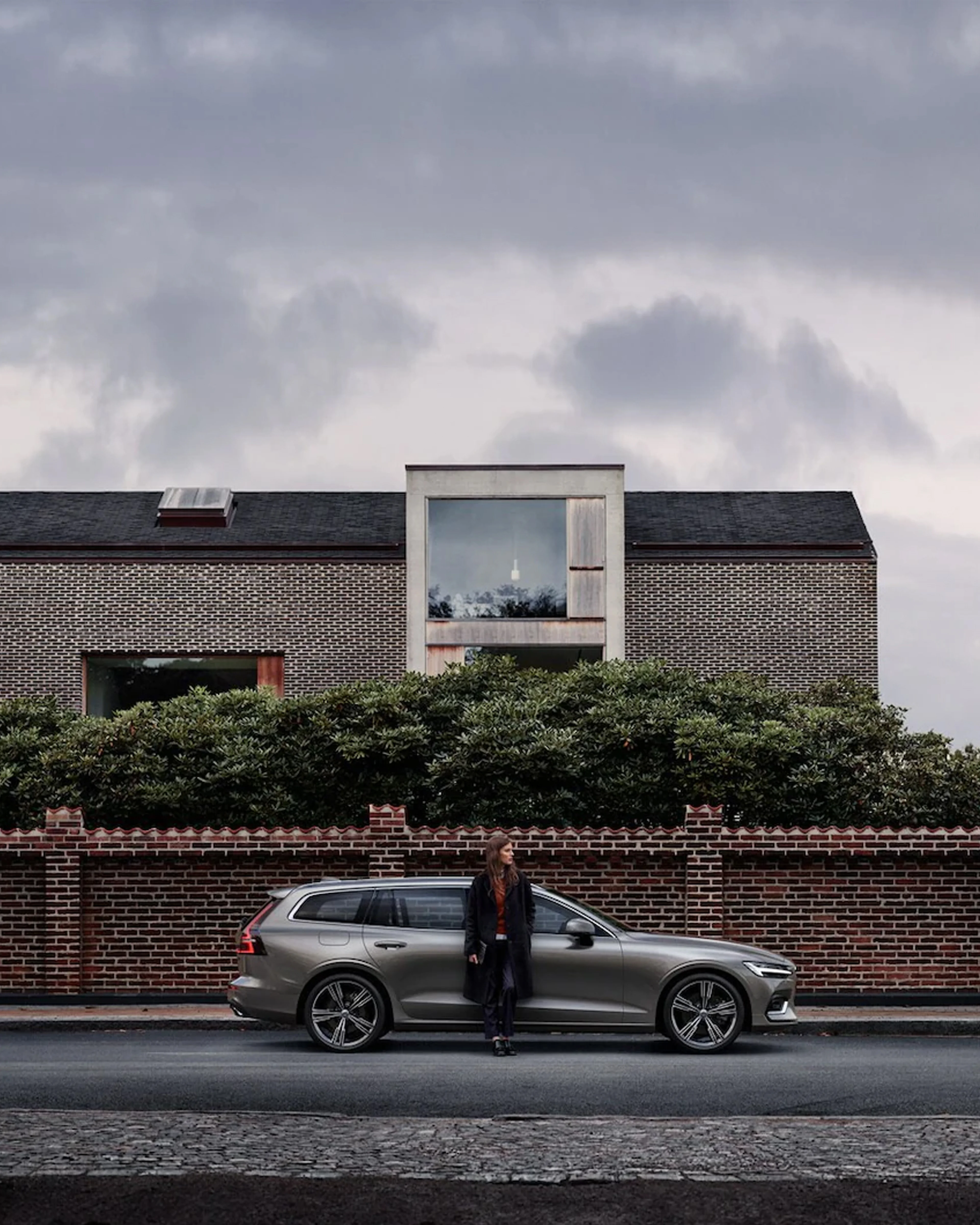 Dame lener seg inntil en parkert Volvo