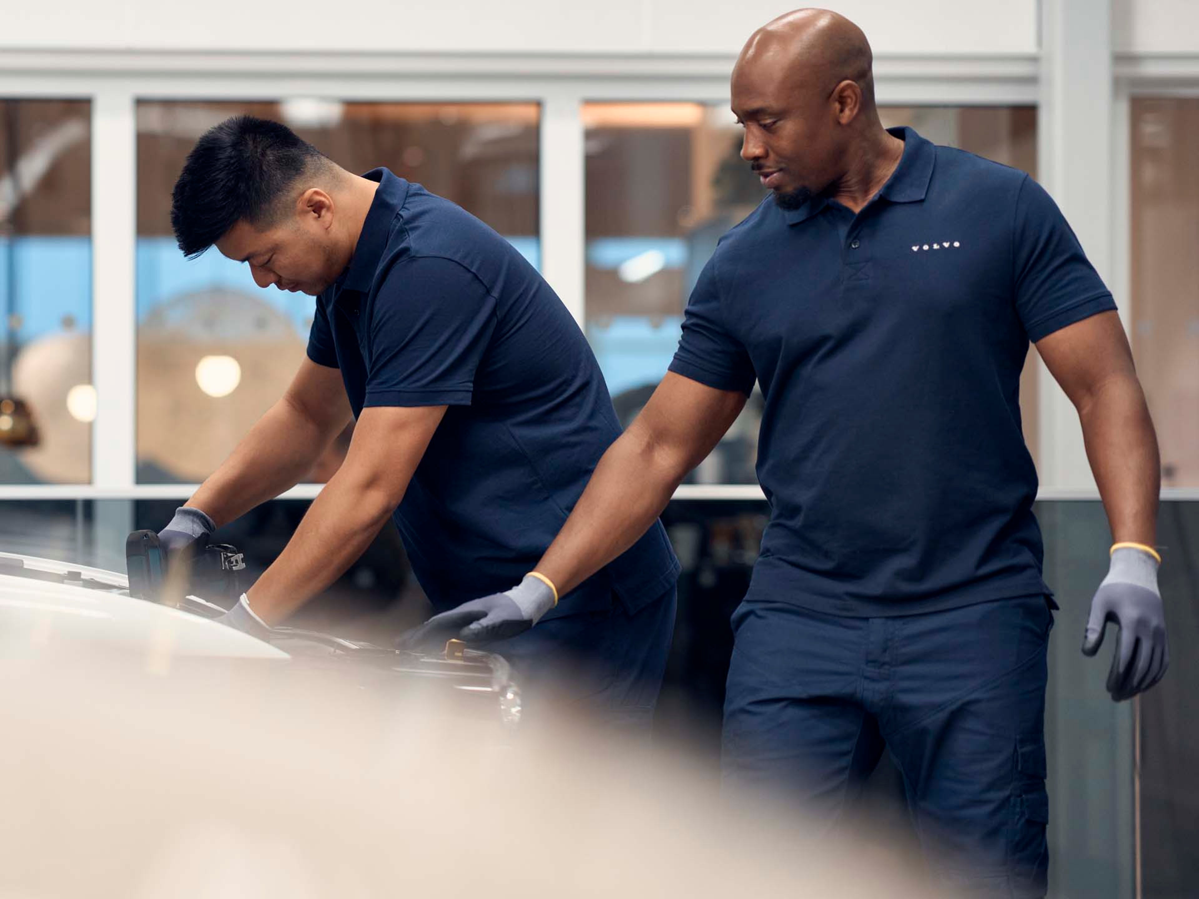 Dos mecánicos en un taller oficial Volvo haciendo comprobaciones en un vehículo