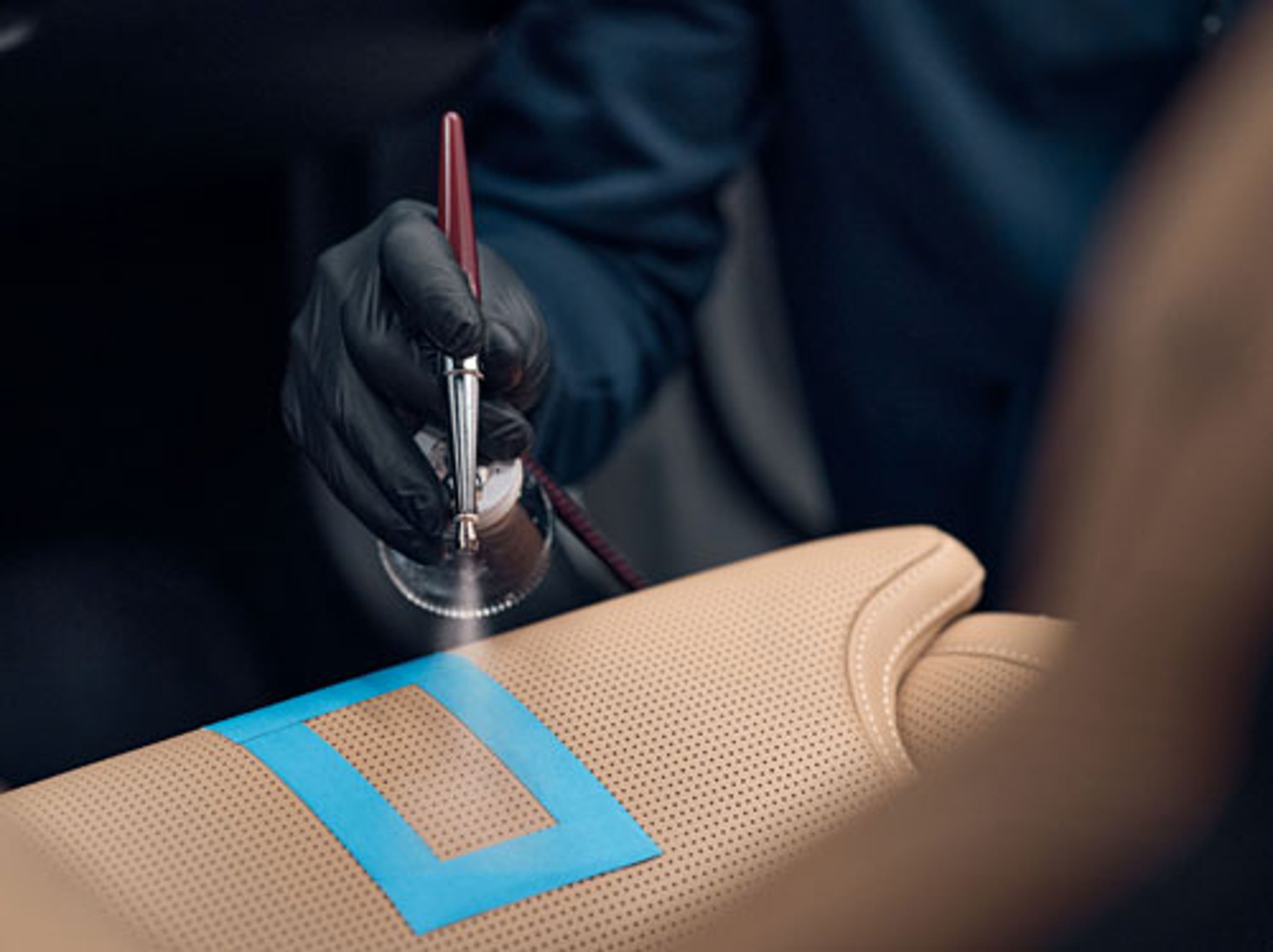 nærbilde av spraylakkering av skinnseter