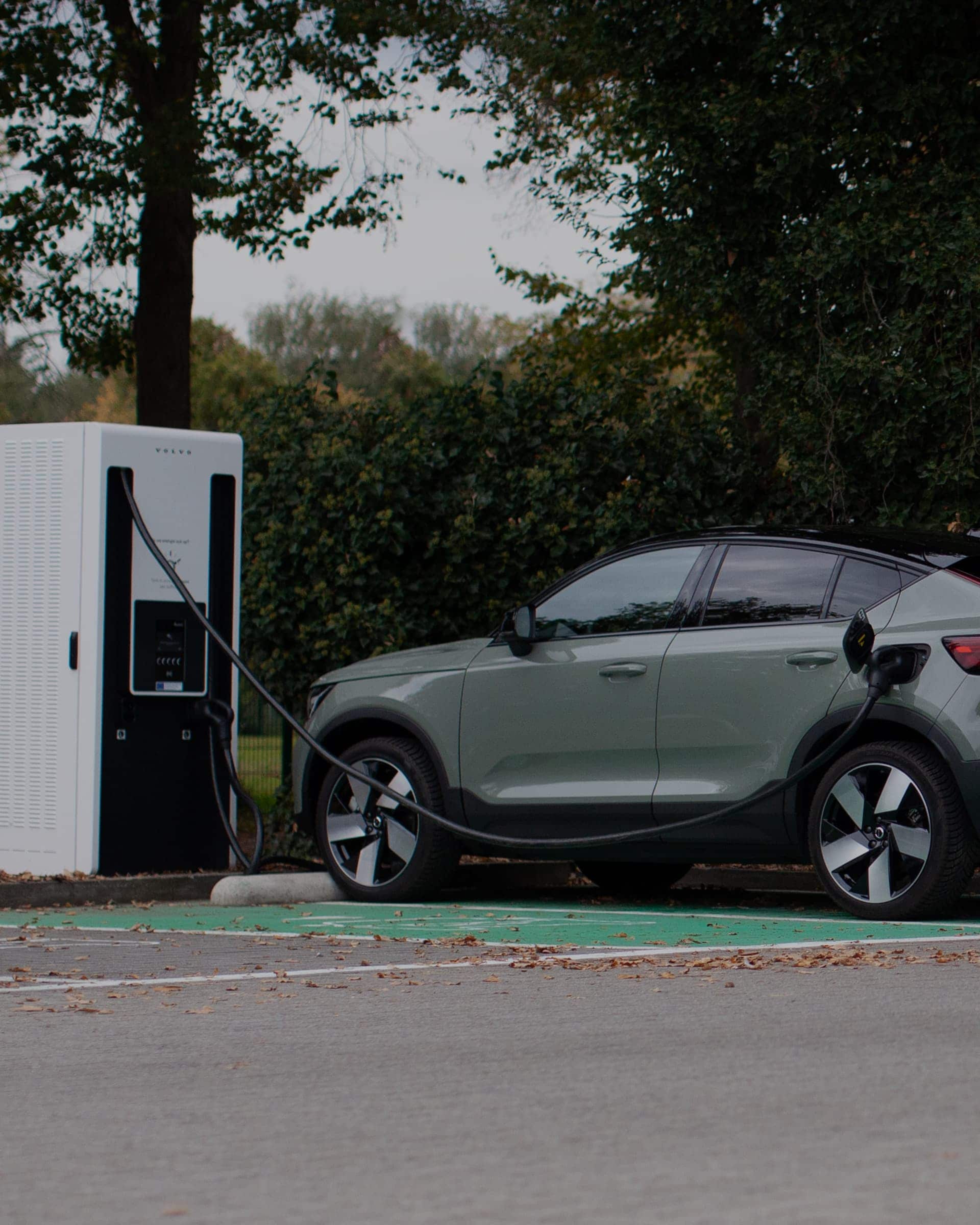 Reflectie van een Volvo EC40 die aan het opladen is aan een oplaadstation.