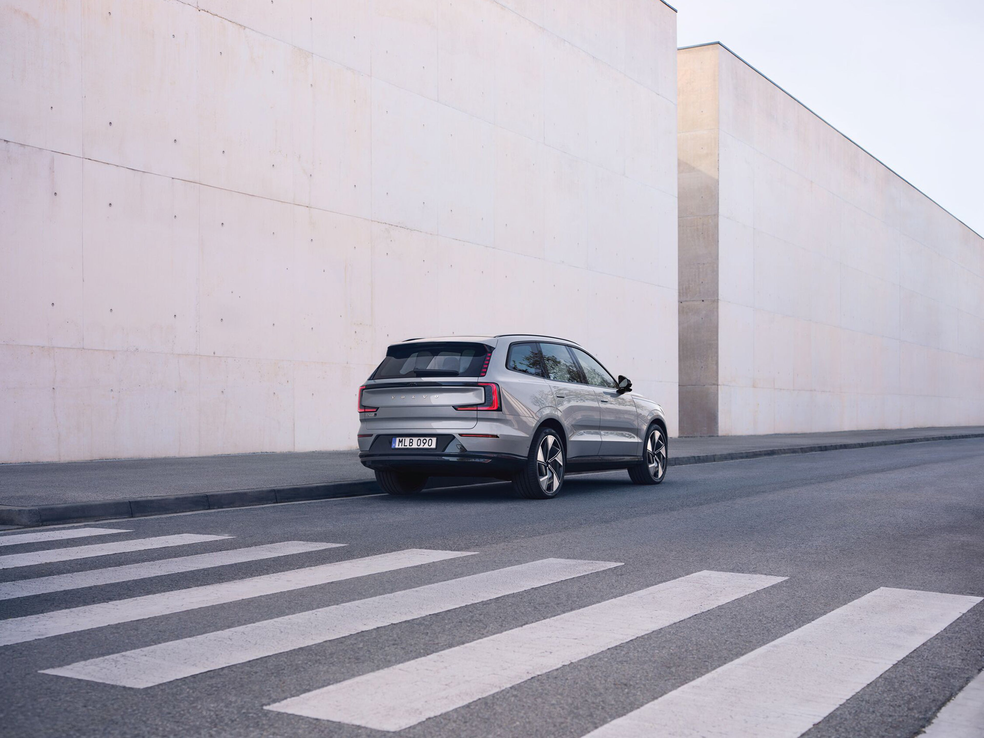 EX90 estacionado no exterior de um edifício de pedra, vista três quartos traseira