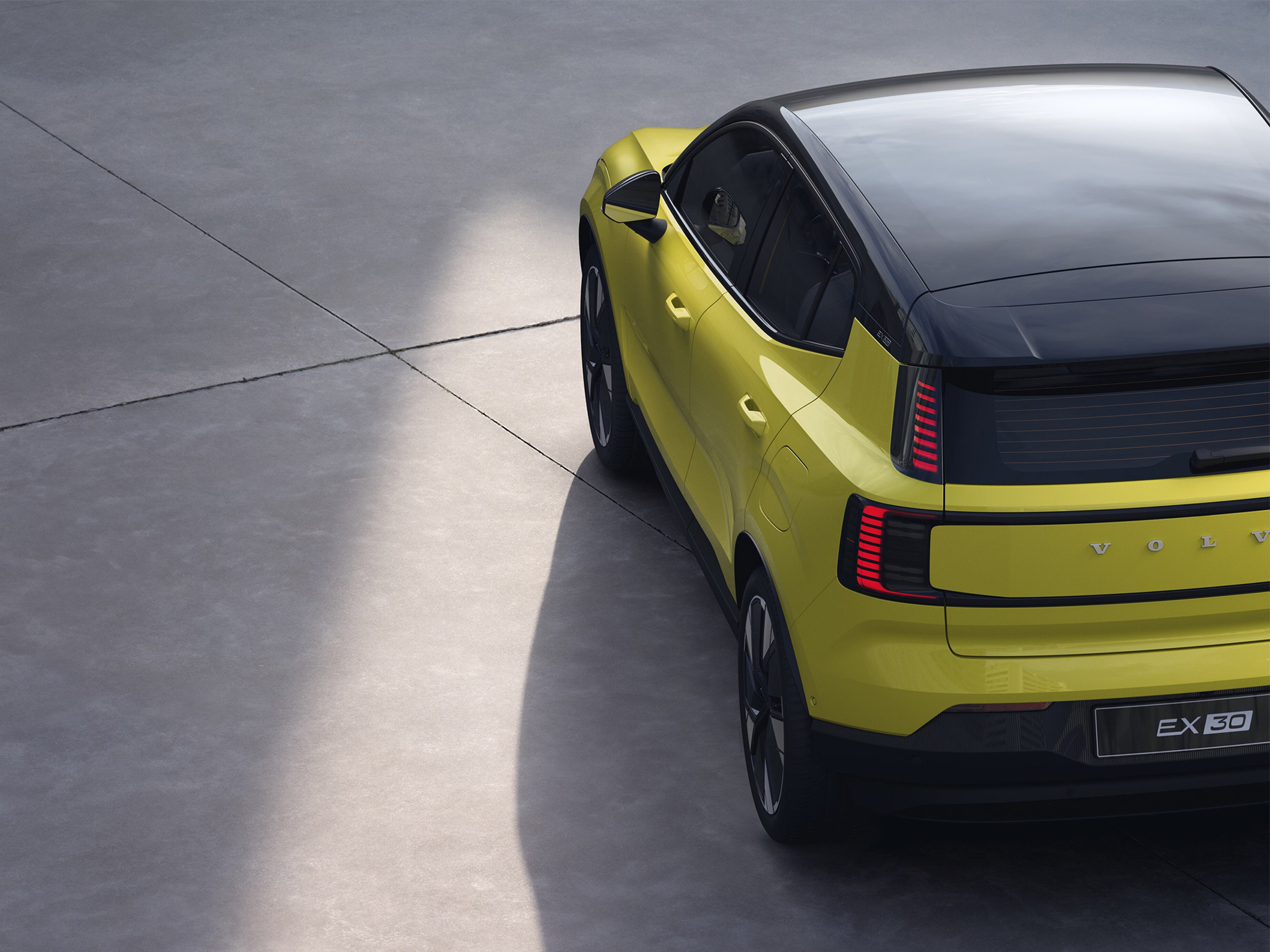 Moss Yellow -värinen Volvo EX30 takaapäin kuvattuna.
