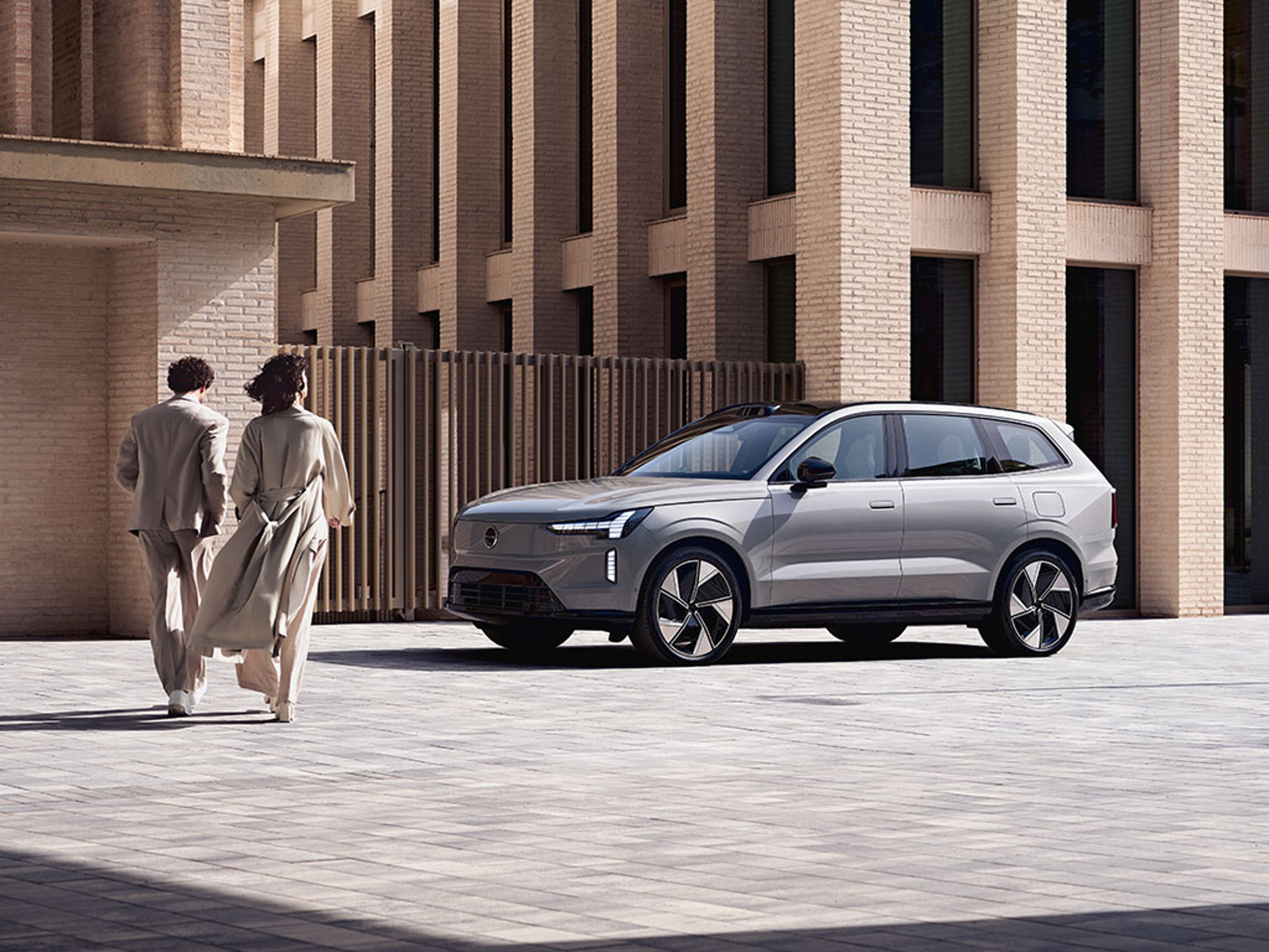 Homme s'éloignant d'une voiture Volvo vue de 3/4