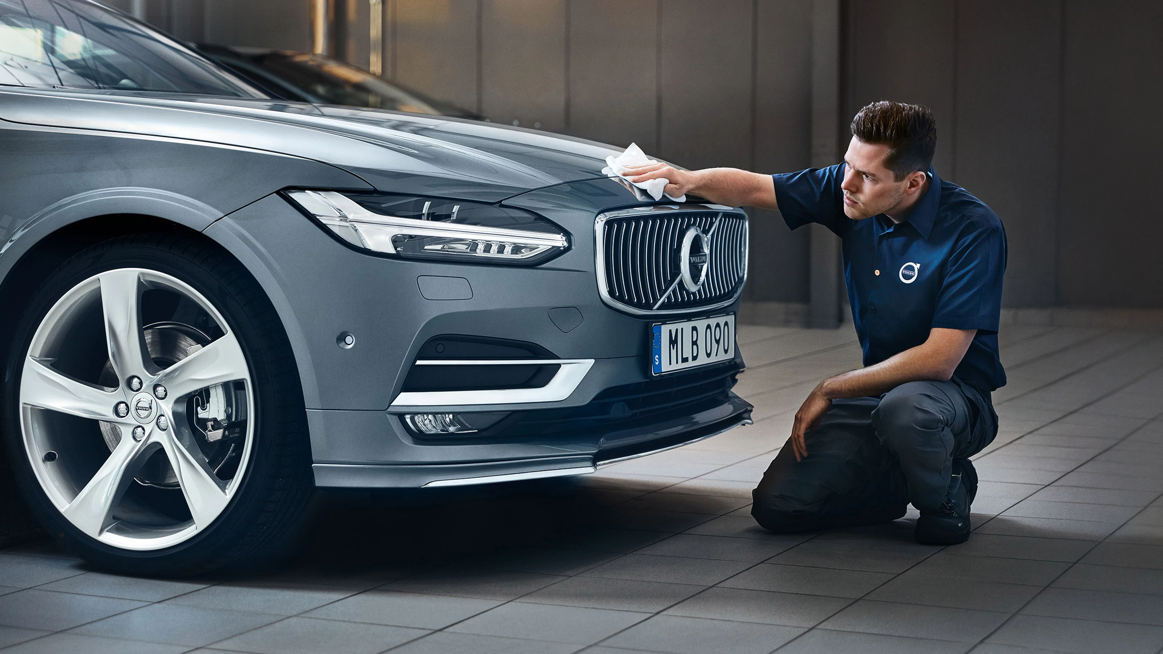 Homme nettoyant l'avant d'une Volvo