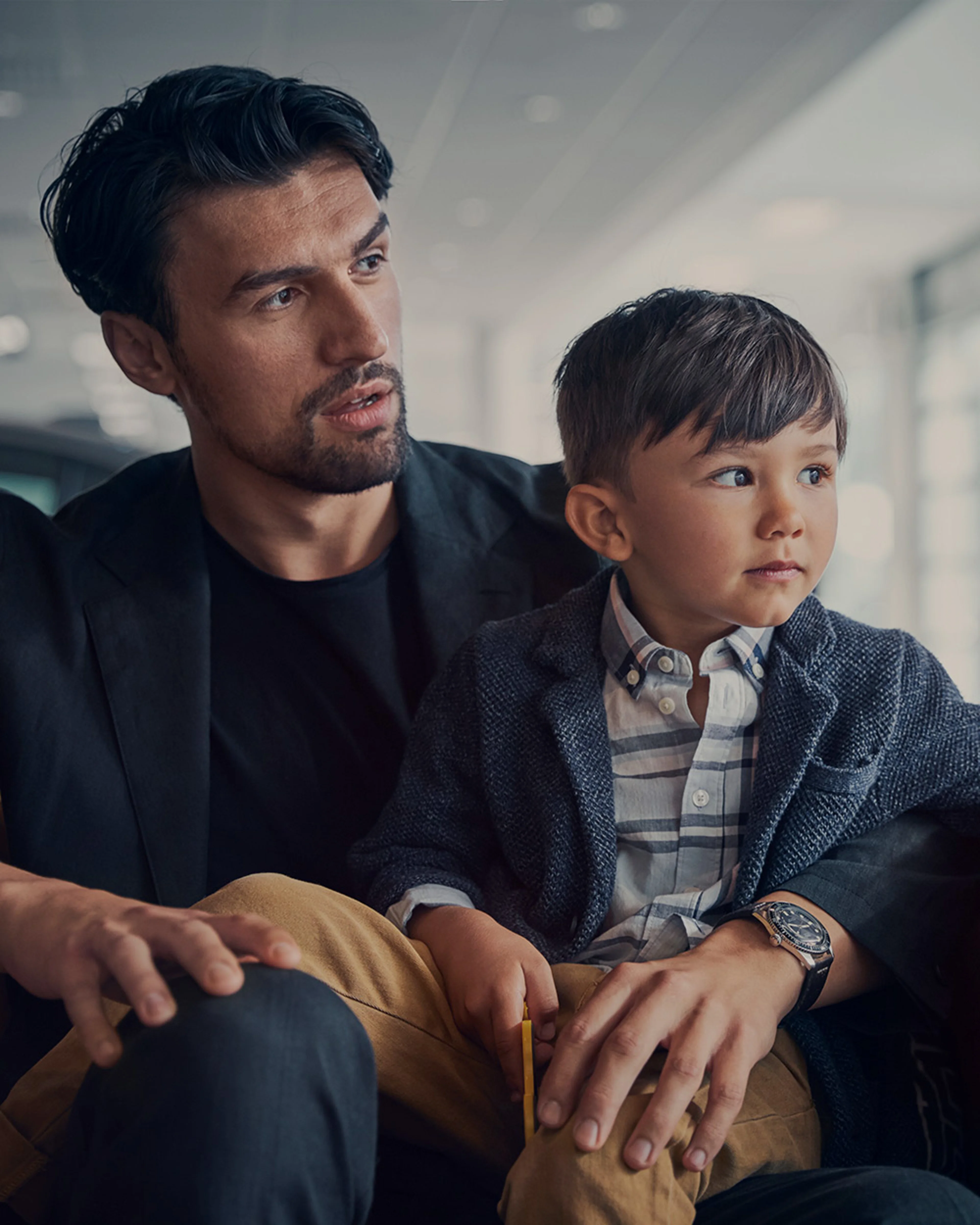 Vader en zoon zitten in showroom en kijken naar rechts