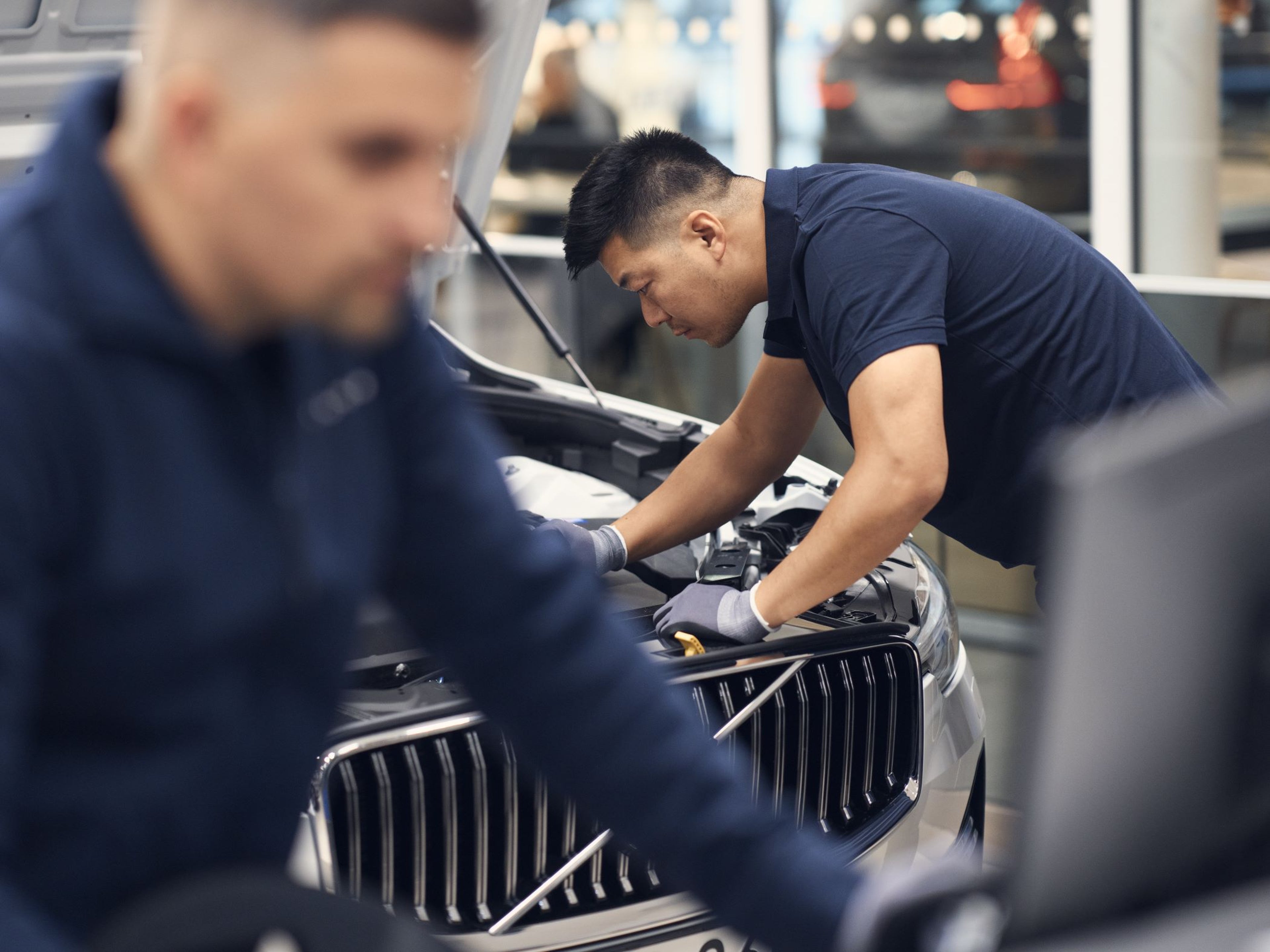 Volvo Schedule Service - person maintaining Volvo vehicle with hood open