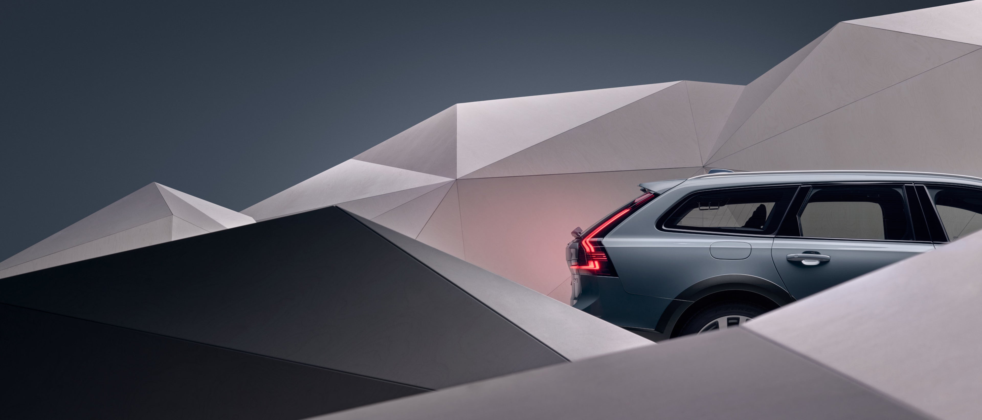 Ein Volvo Fahrzeug fährt durch eine Landschaft aus geometrischen Formen