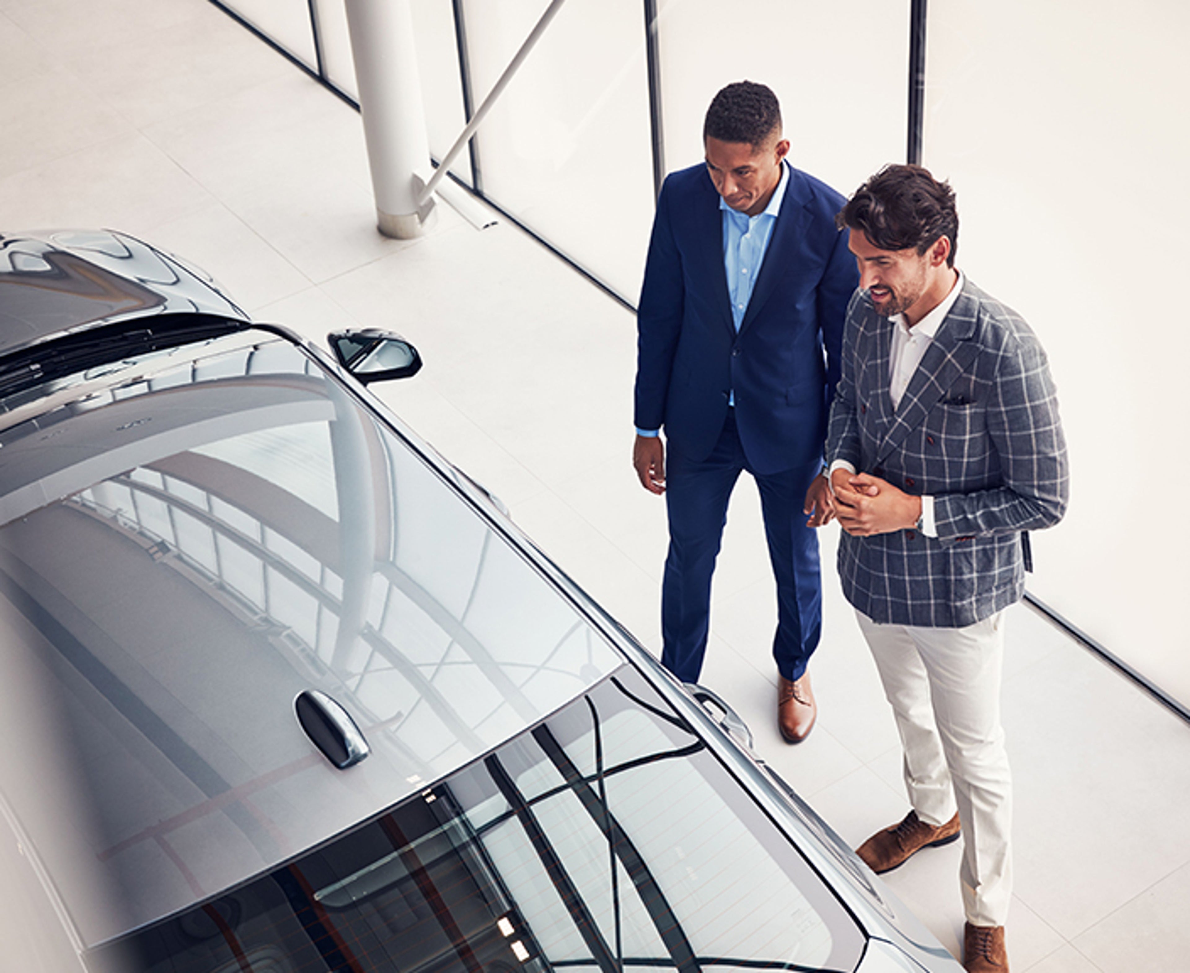 Two men discuss a vehicle in a showroom