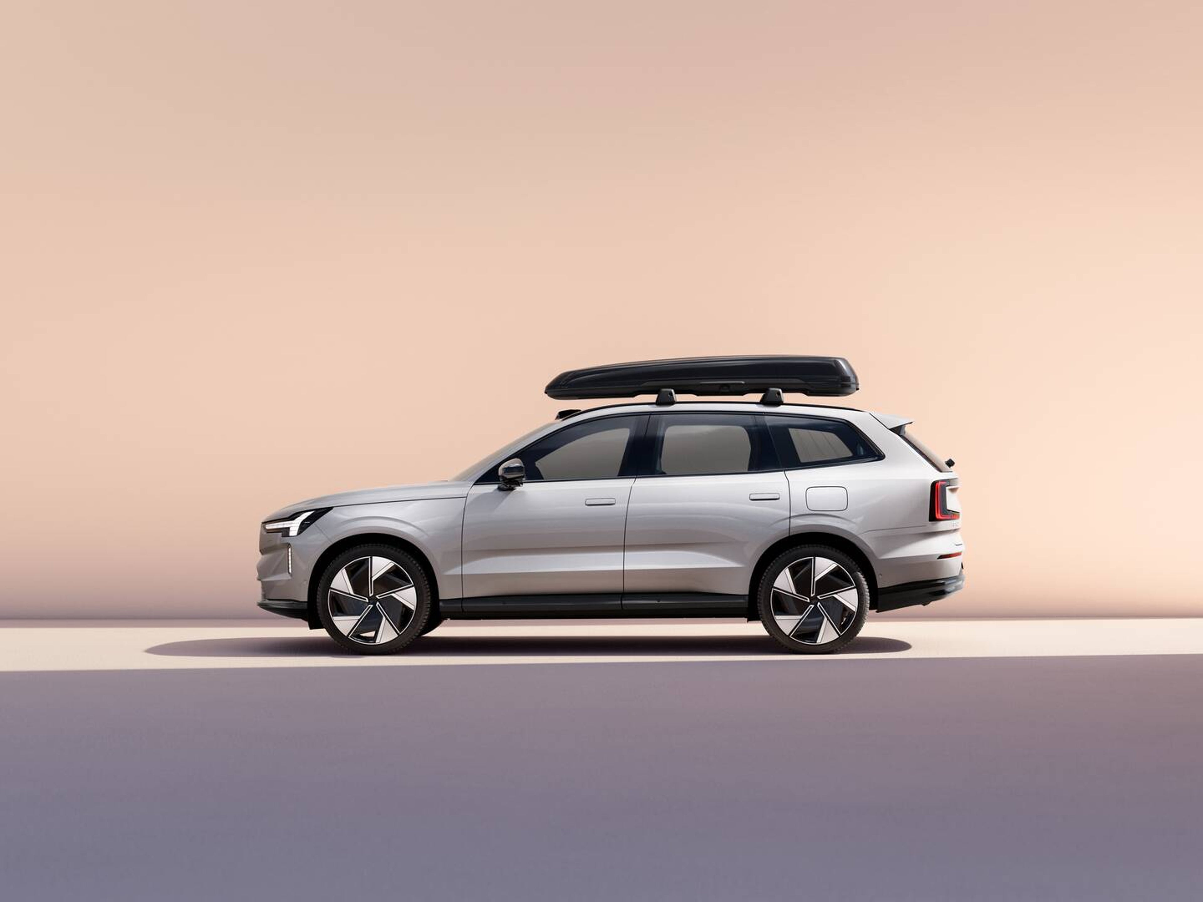 Side view of silver Volvo with roof box accessory attached